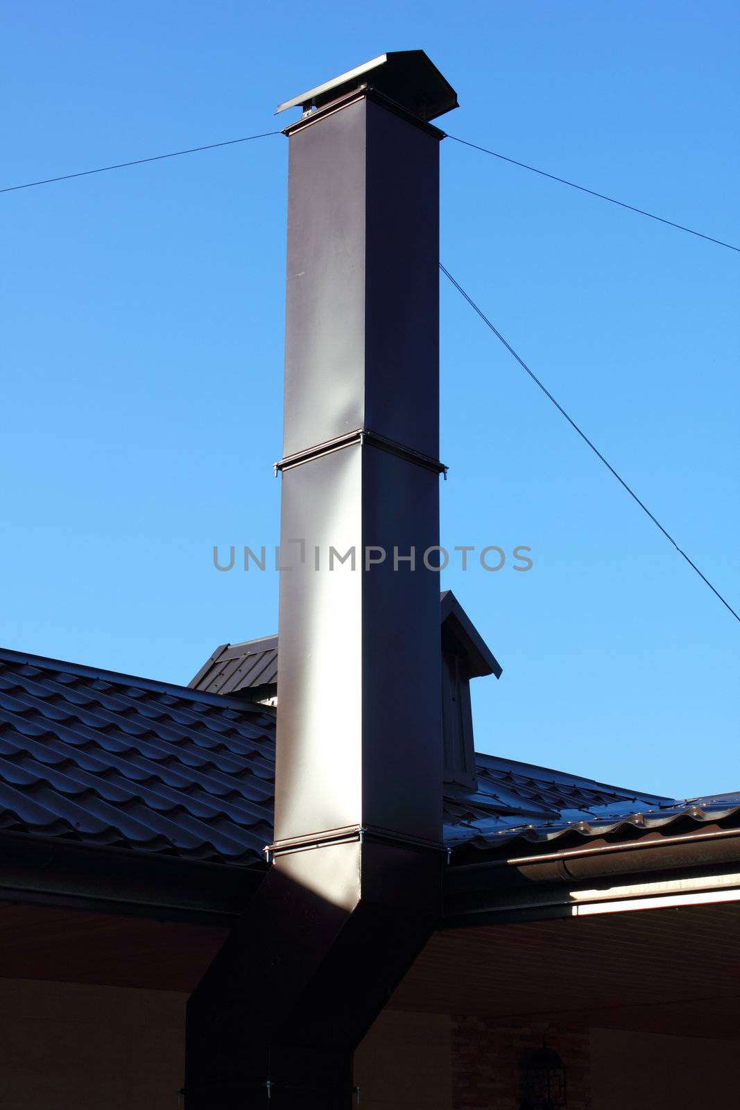 Chimney and roof on the sky background.