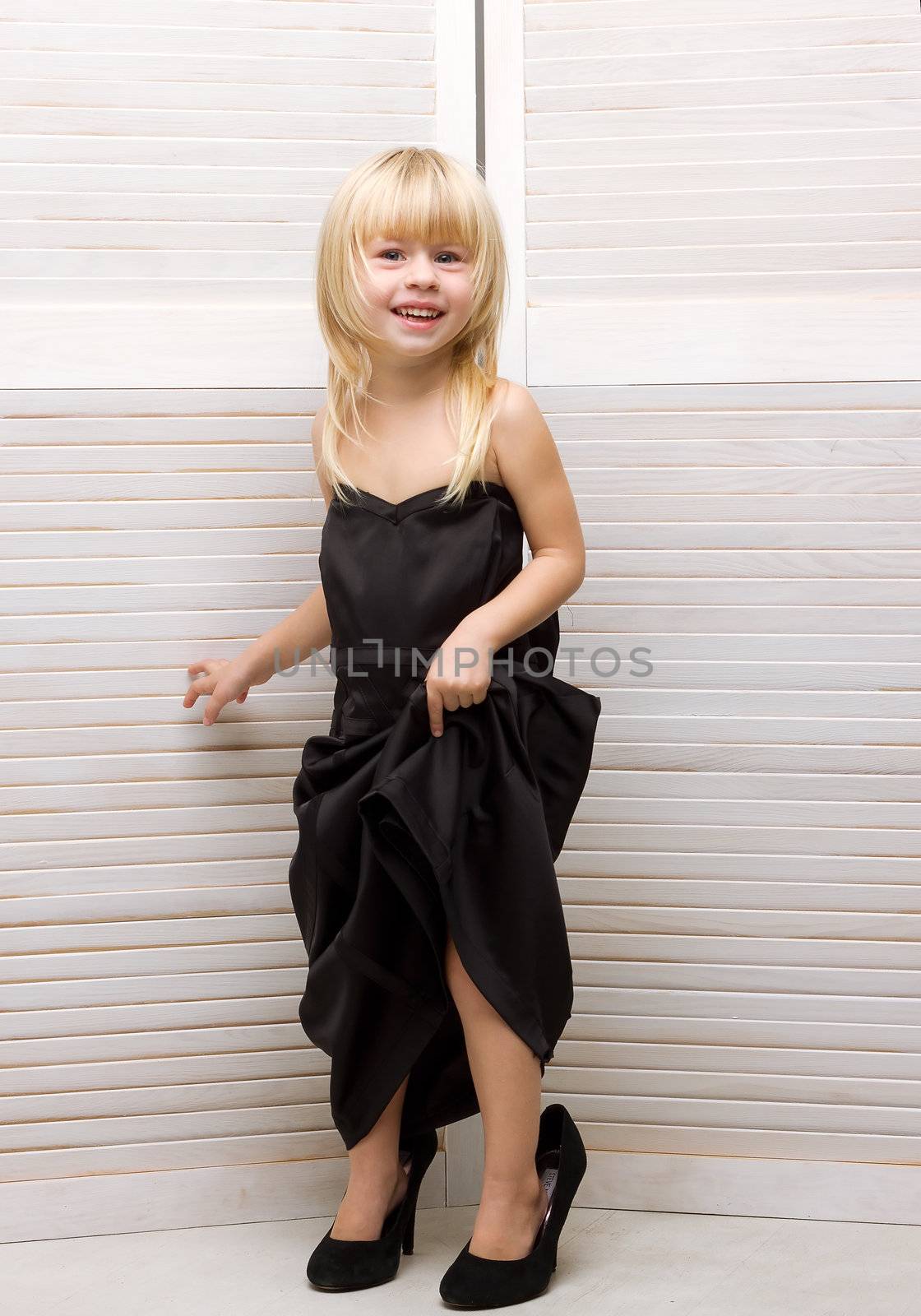 Girl 3 years old in my mother's black dress and high heels