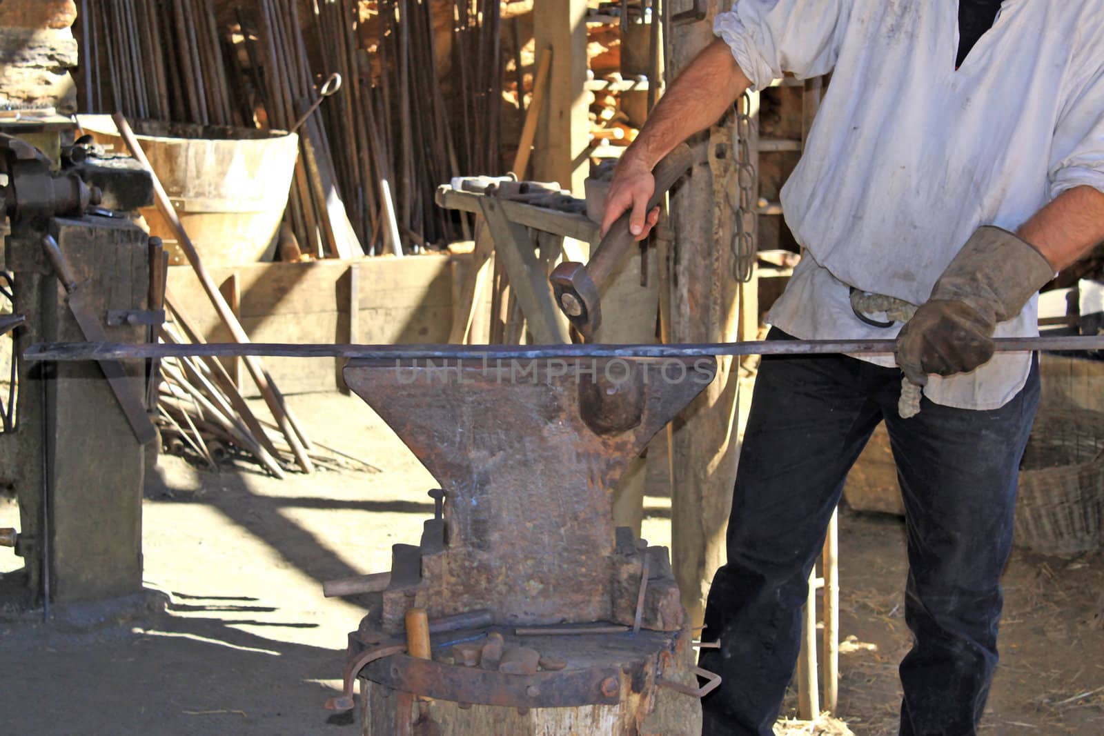 an artisan blacksmith in his workshop in the Middle Ages