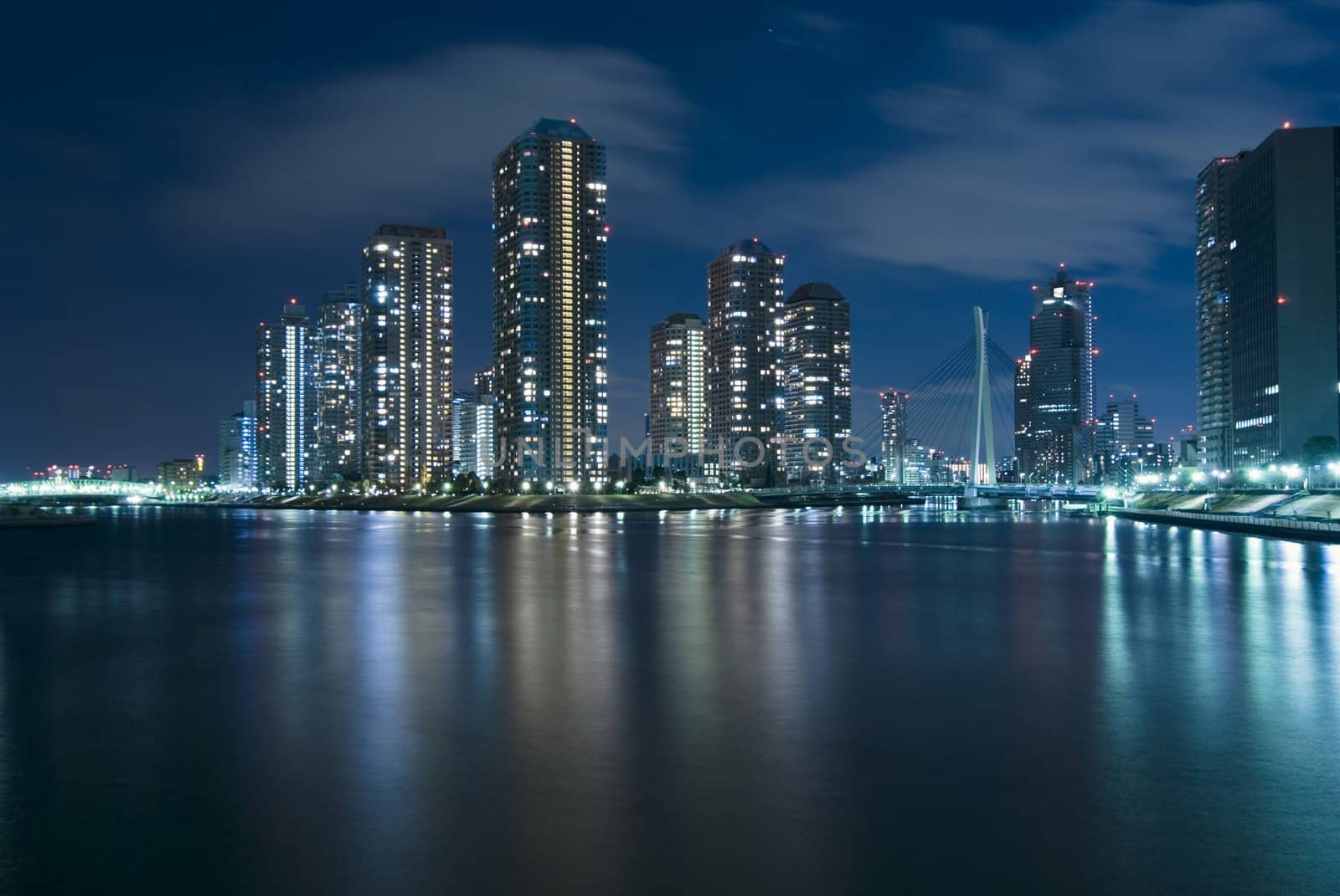 modern Tsukuda district of Tokyo at night over waters of Sumida River