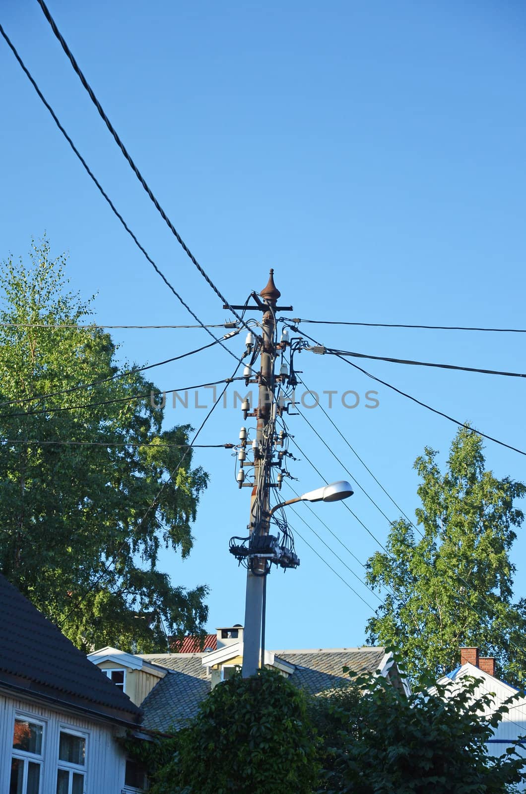 Telephone and electricity wires on a post in an urban environment