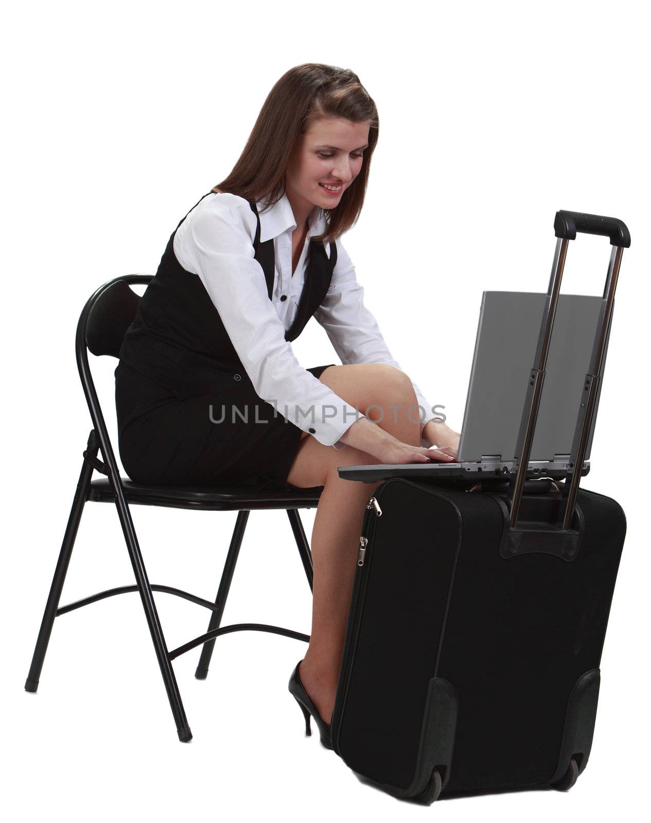 Young woman traveler working in a hurry on her latop on a suitcase- isolated against a white background.