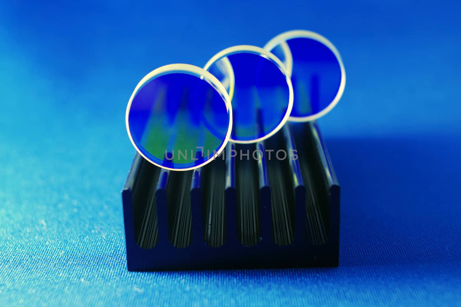 specially coated optical mirrors for laser industry and science on the black metallic rail; selective focus on front mirror