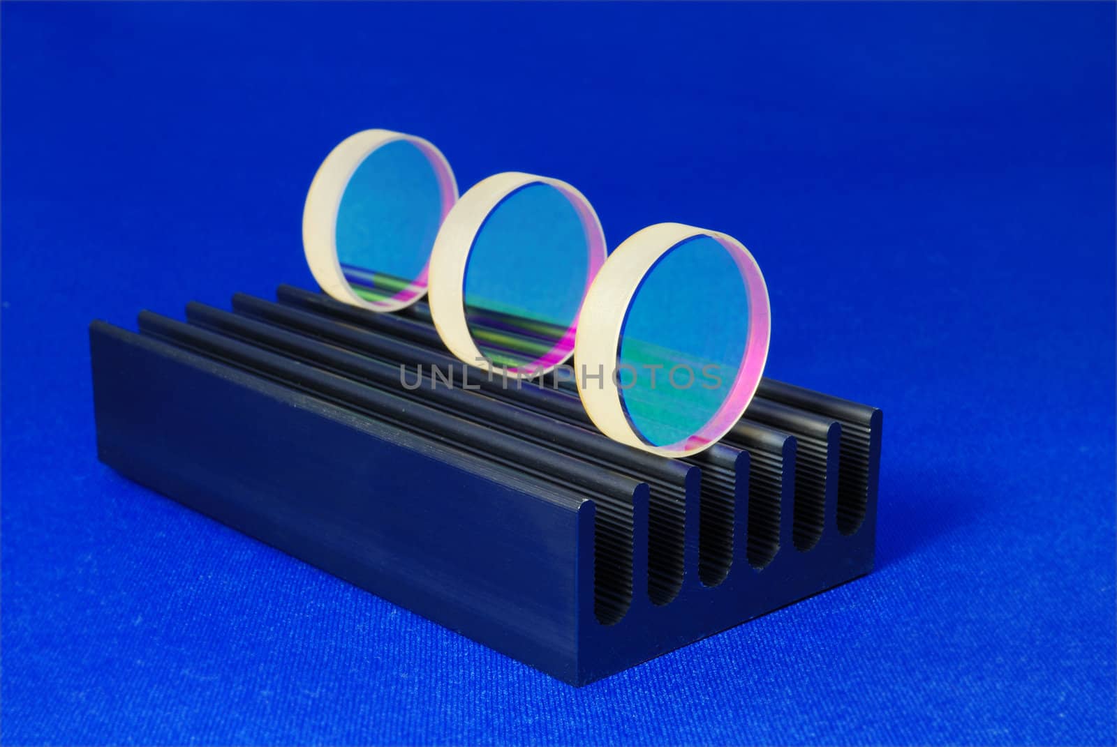  specially coated optical mirrors for laser industry and science on the black metallic rail; selective focus on front mirror