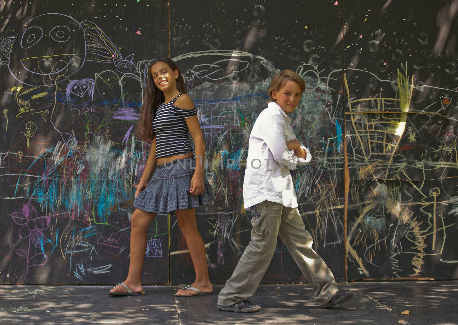 Portrait of  dancing boys and girls near a wall with graffiti.