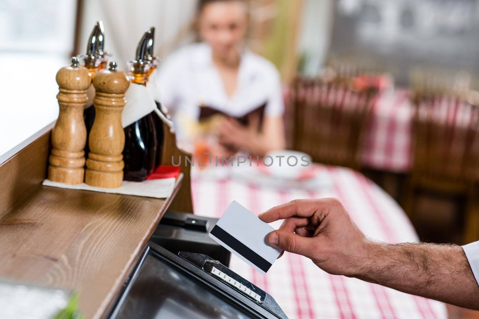 waiter inserts the card into a computer terminal, against visiting the restaurant