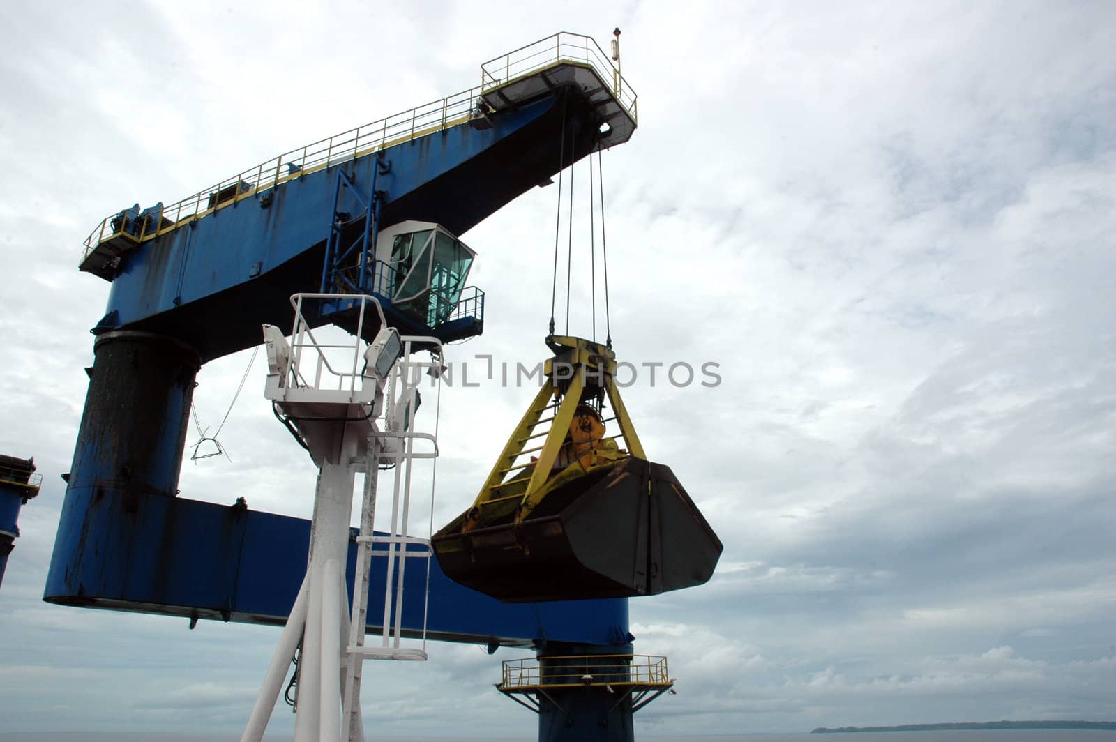 coal is being loaded onto tankers with a blue crane by antonihalim