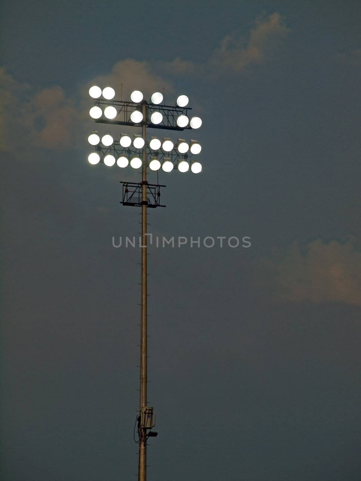 Stadium Lights Against an Evening Sky at Dusk by Frankljunior