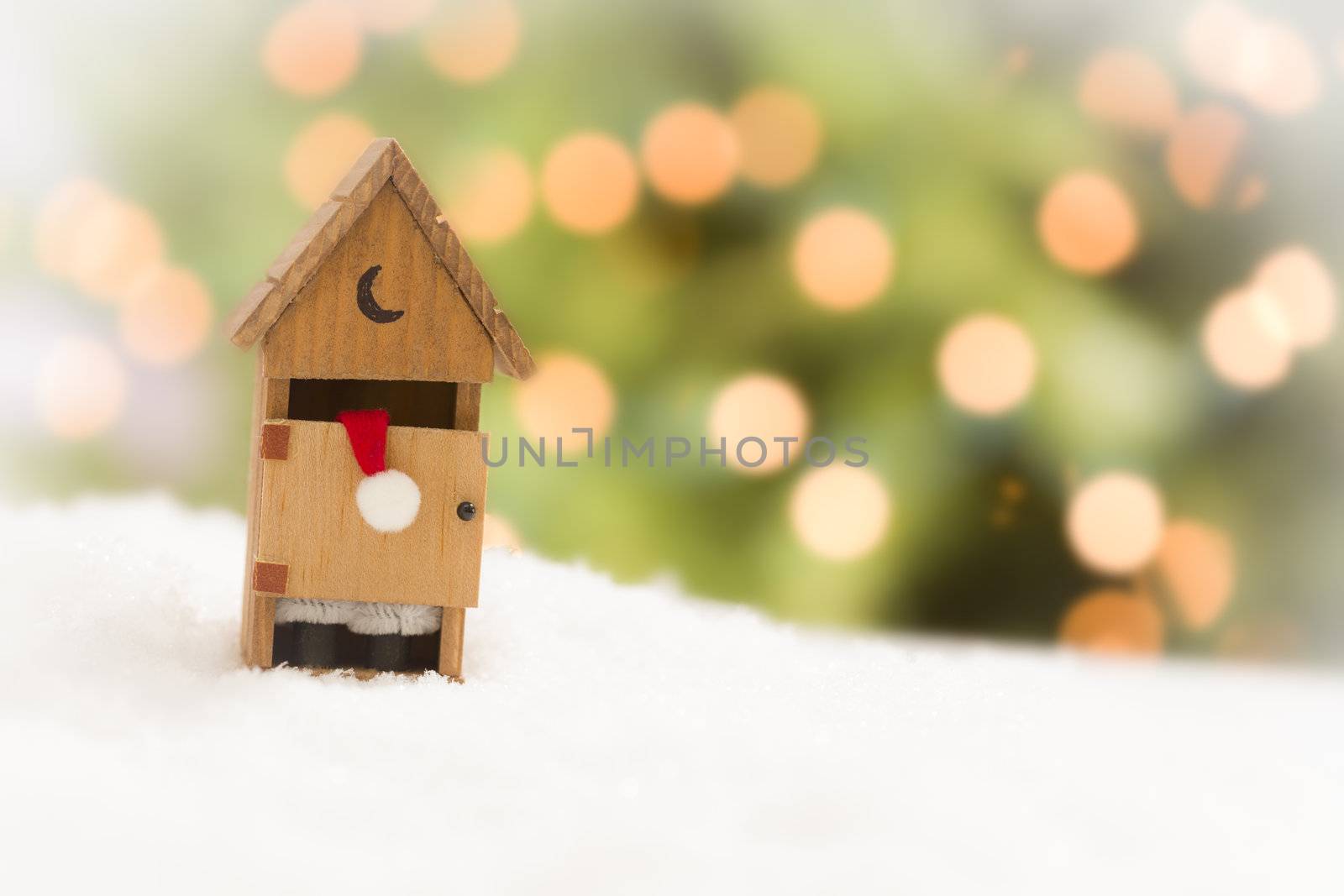 Santa in A Miniature Outhouse on Snow Over and Abstract Background.