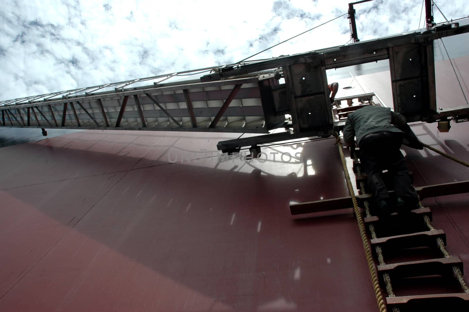 a man climbing a ladder on a tanker by antonihalim