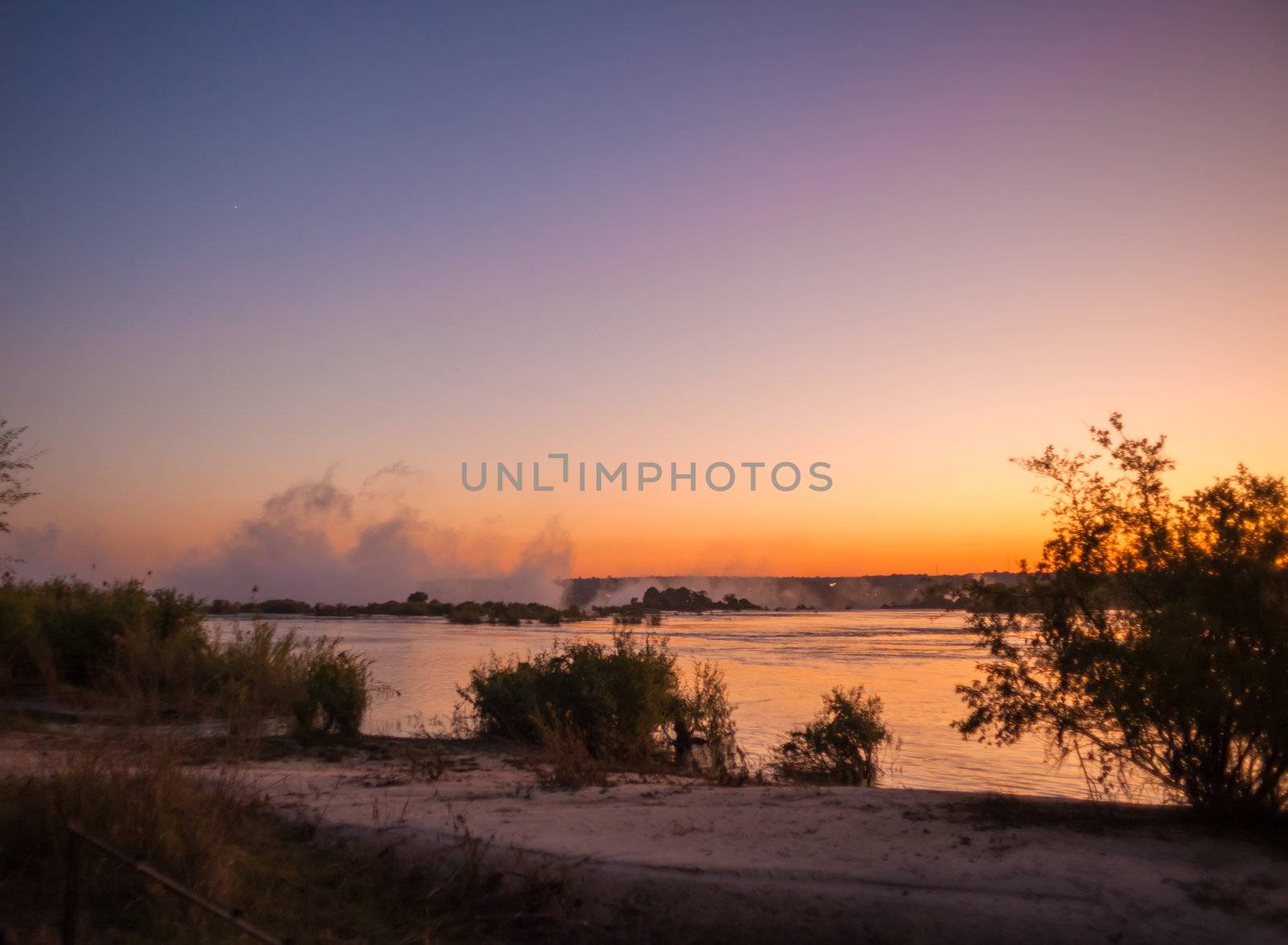 Plume of mist rising from Victoria Falls at sunset