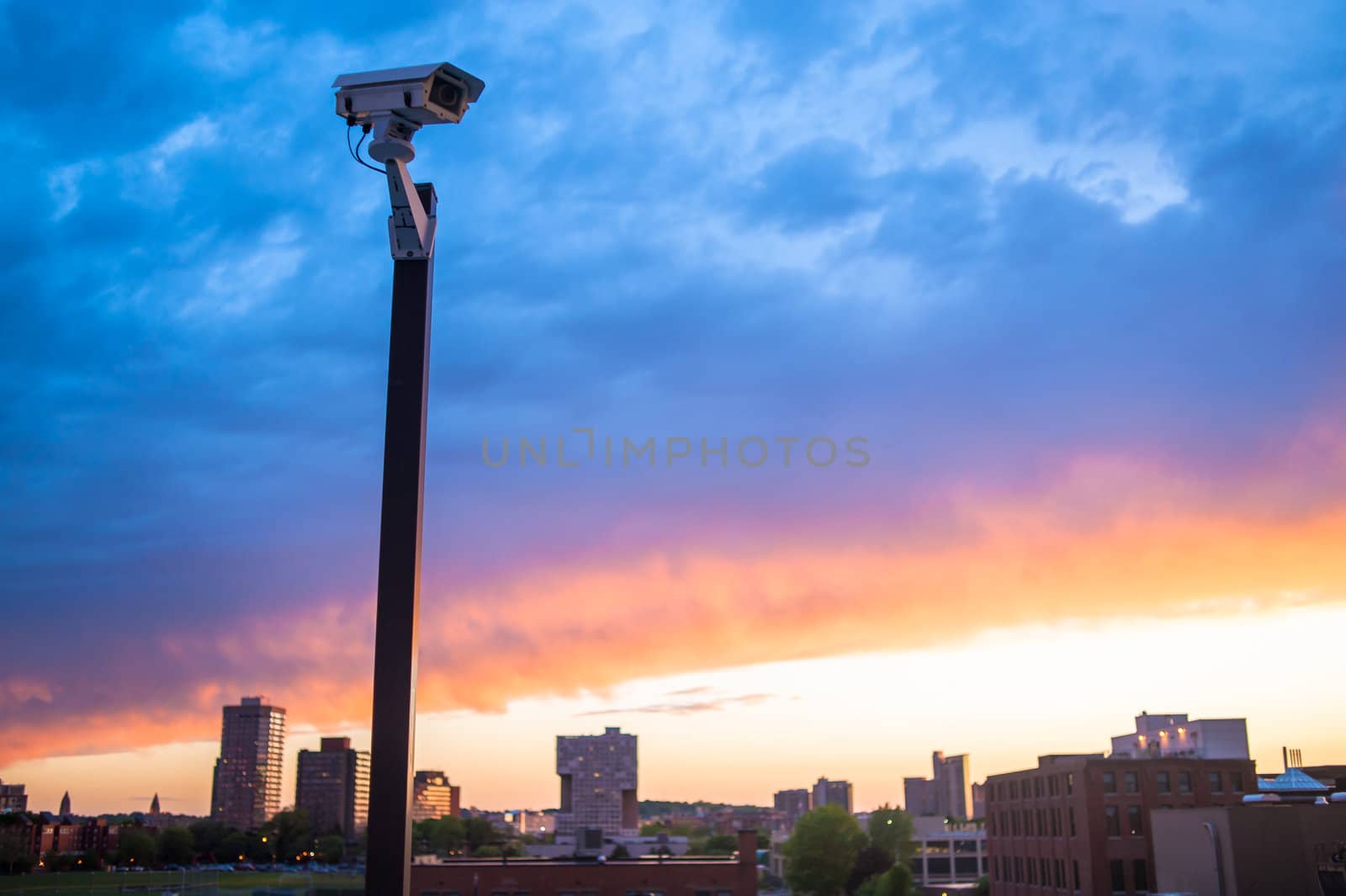 Urban security video camera outdoors at sunset