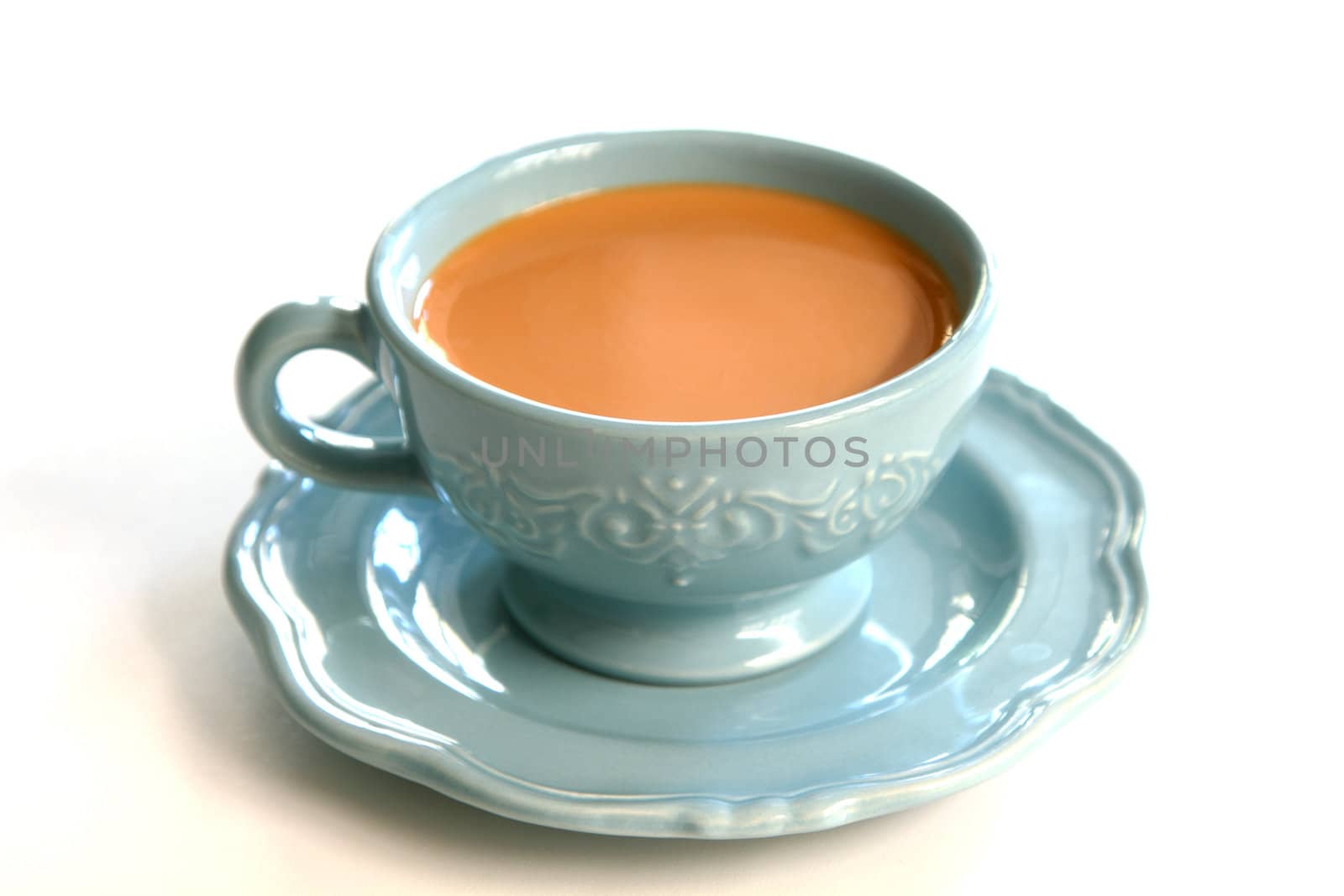 Tea with milk in blue cup and saucer