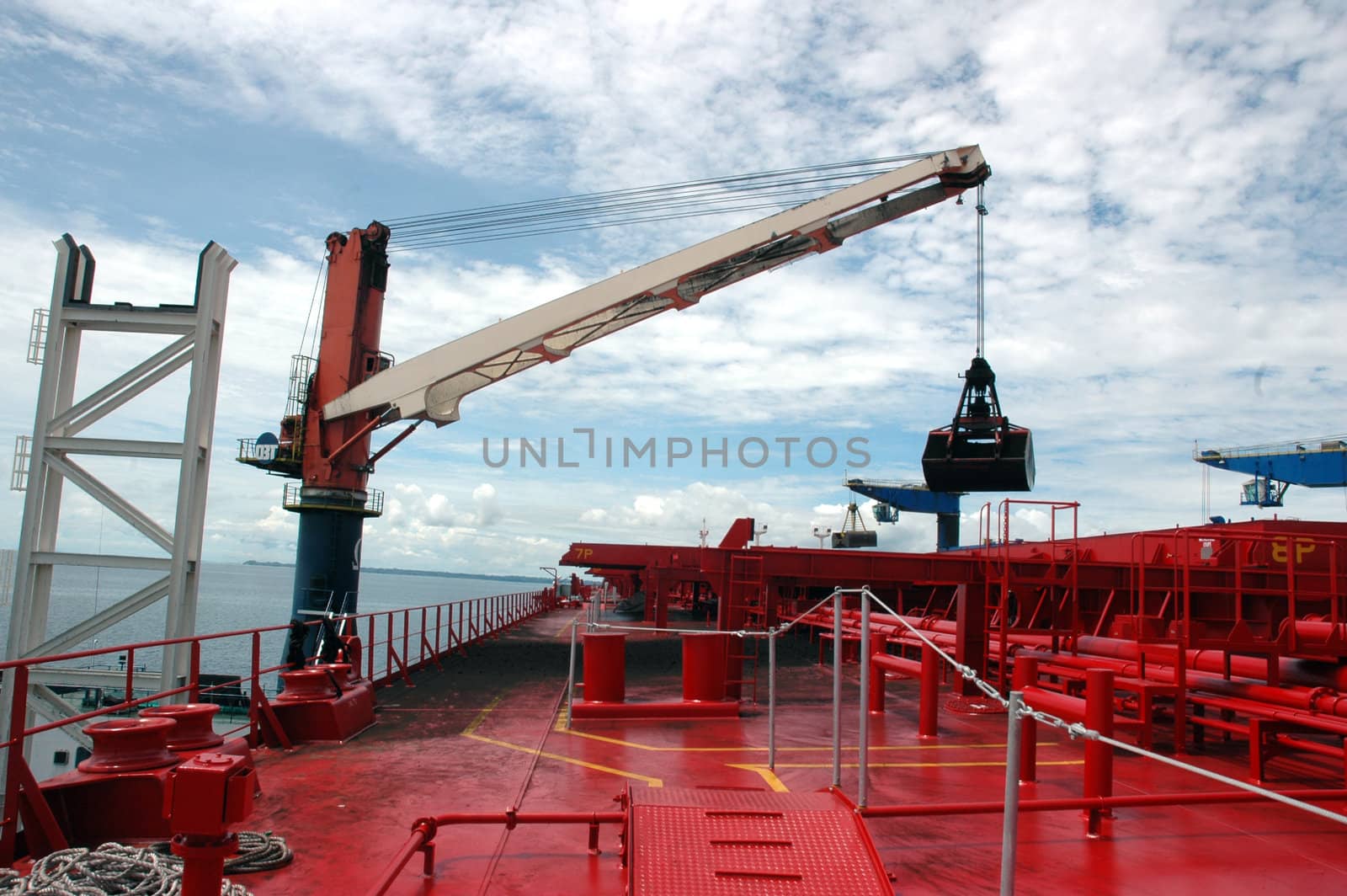 coal is being loaded onto tankers with a crane by antonihalim