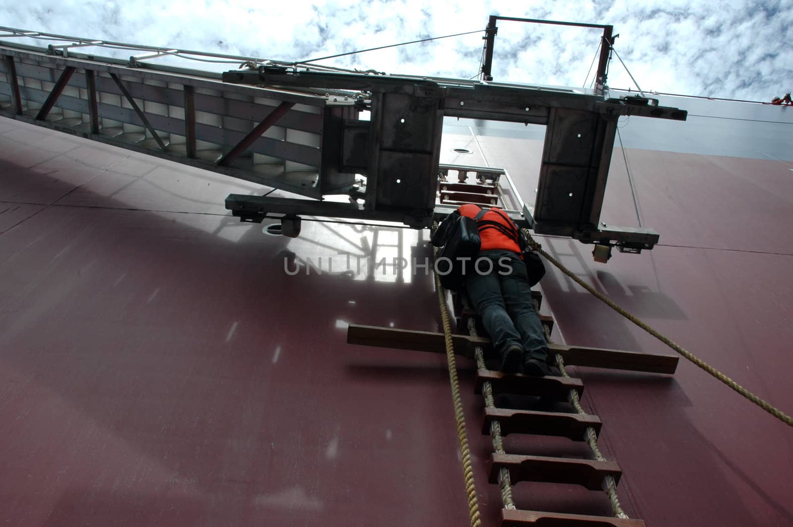 a man climbing a ladder on a tanker by antonihalim