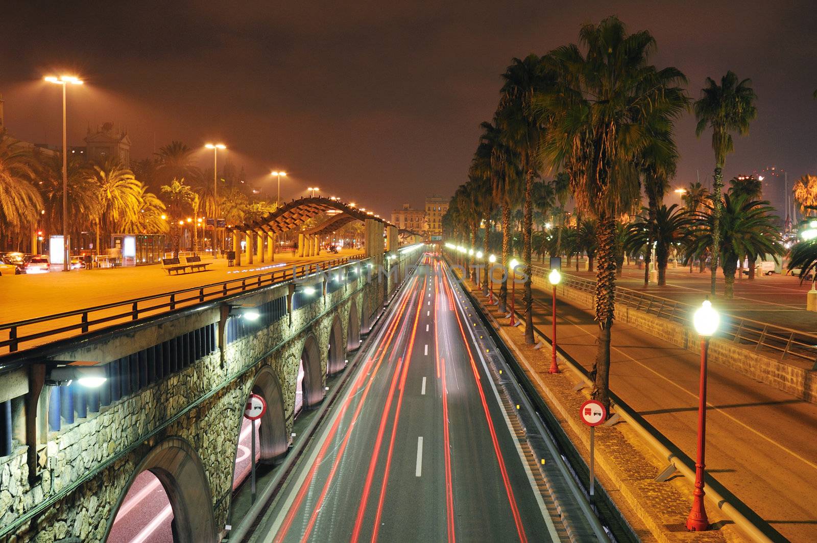 scenic night view to the famous Passeg de Colom street close to Barcelona port area; sharp focus on foreground wall and right light