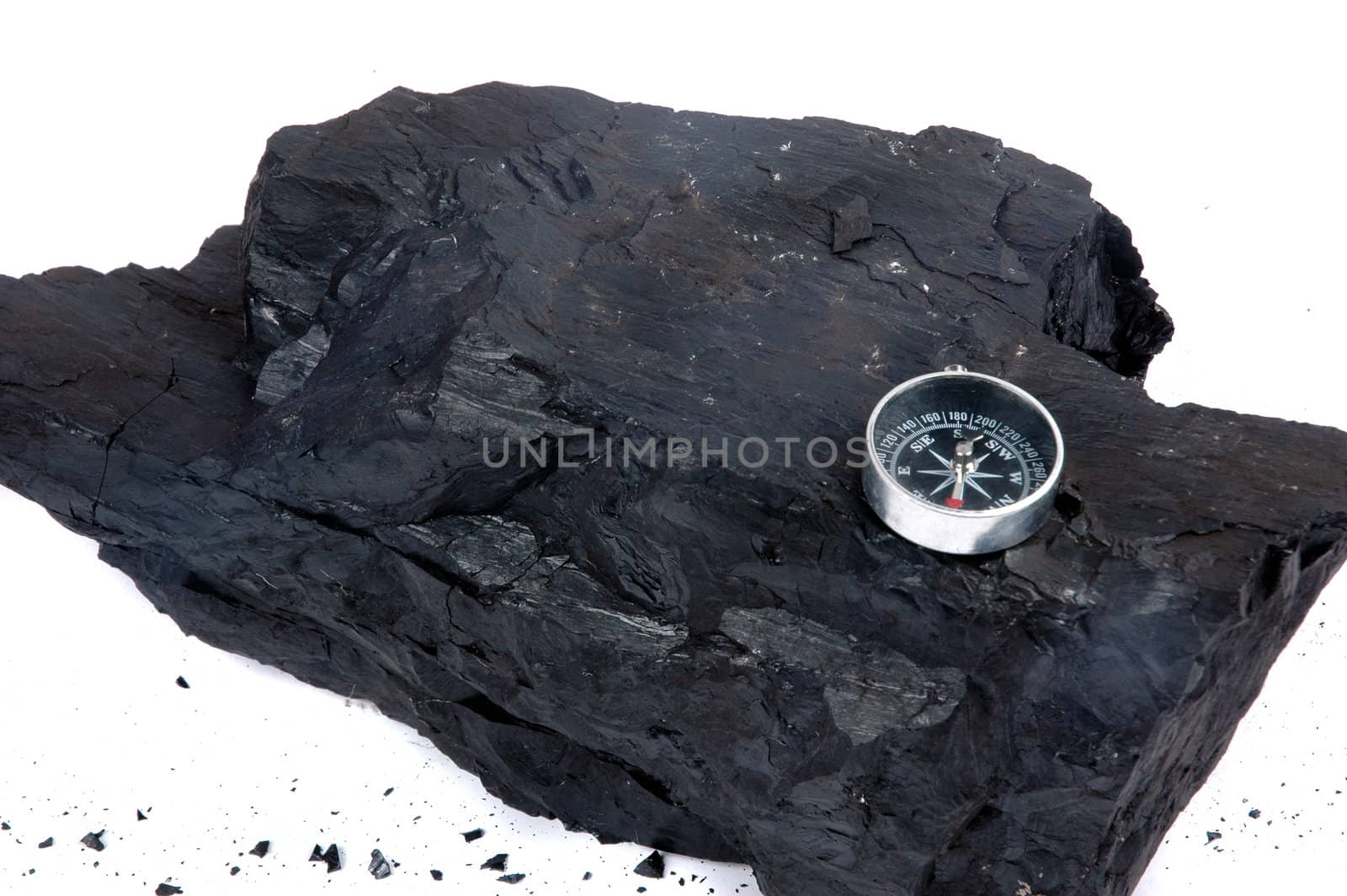 a lump of coal and compass isolated on white background