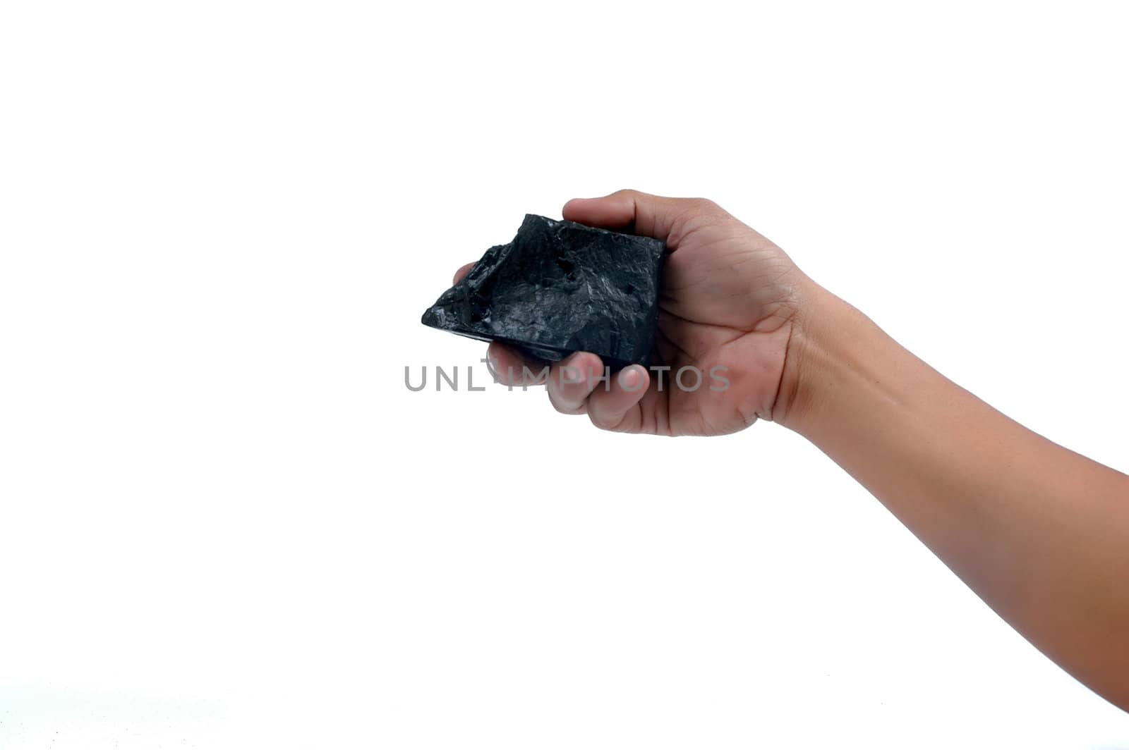 male hand holding a little lump of coal  isolated on white background