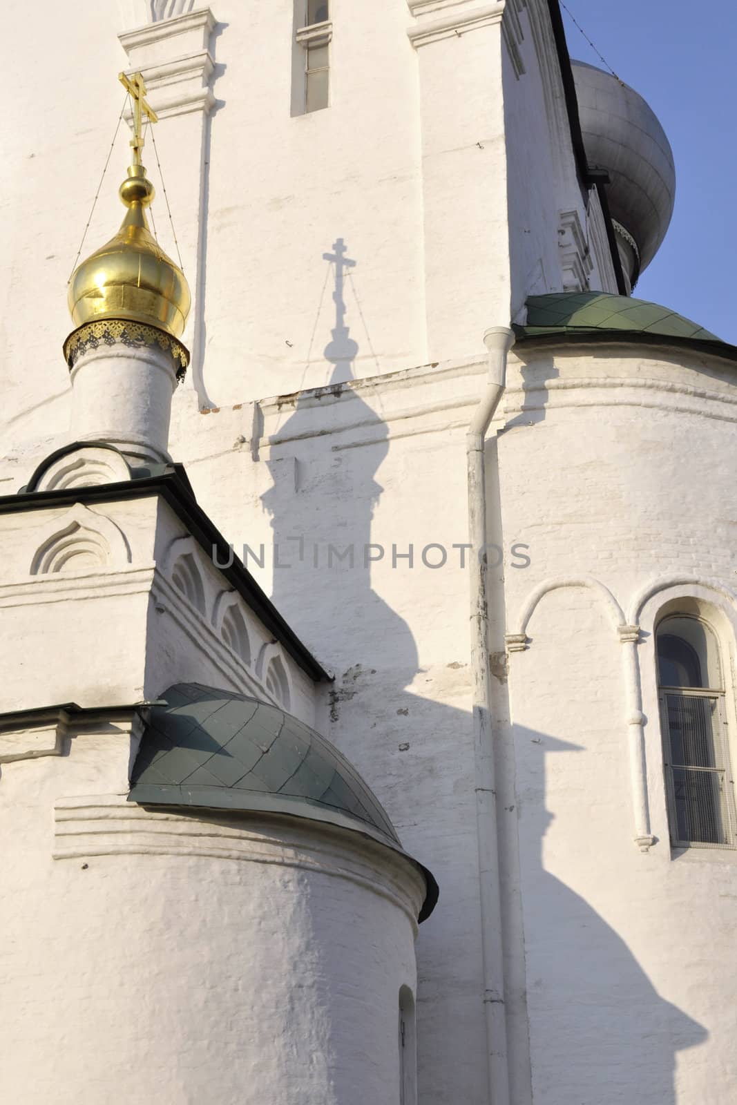 evening shadow of orthodox cross on white wall at Novodevichy convent site in Moscow