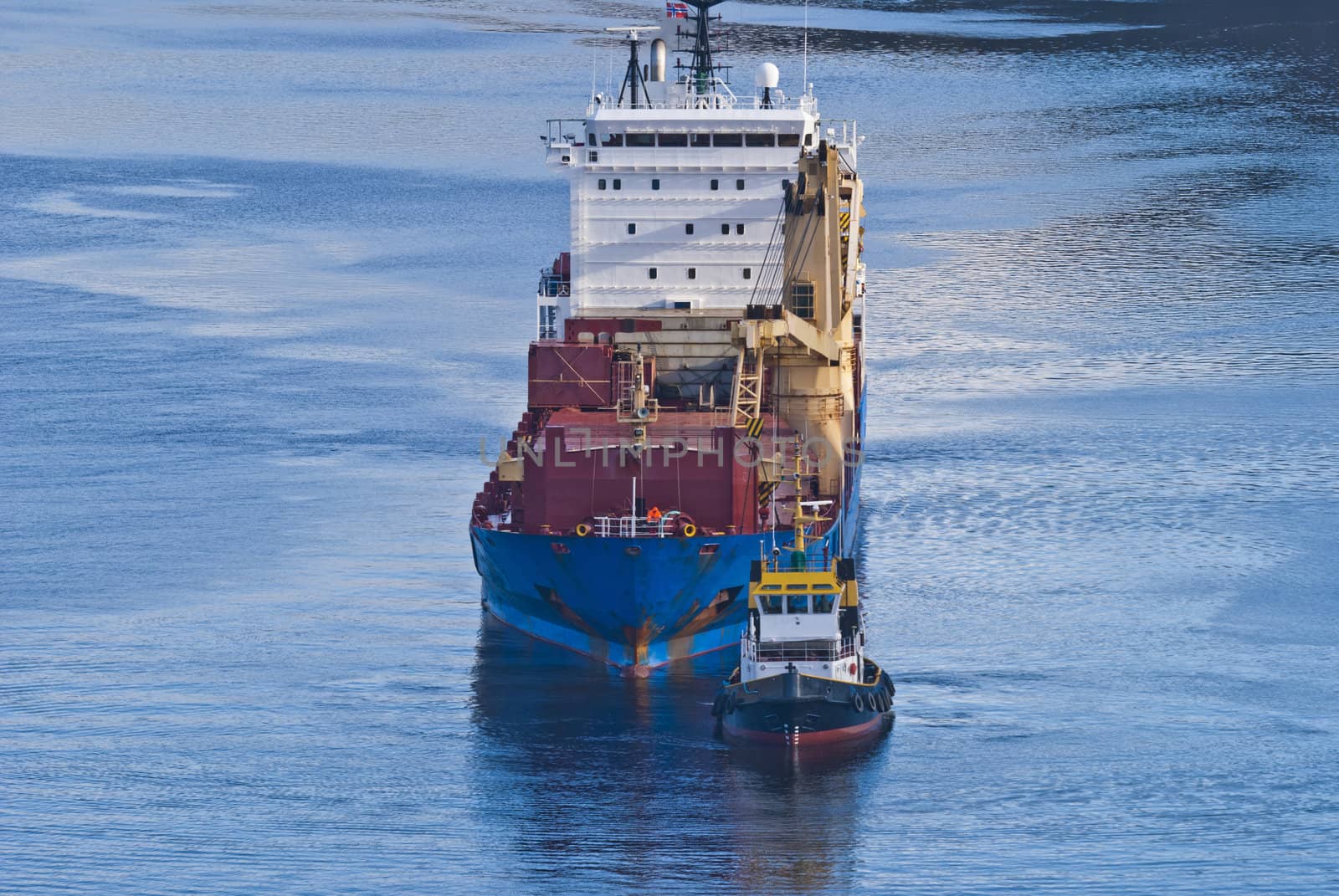 tug herbert moving into ringdalsfjord to assist bbc europe out of the narrowest strait in the fjord, bbc europe is a big cargo ship