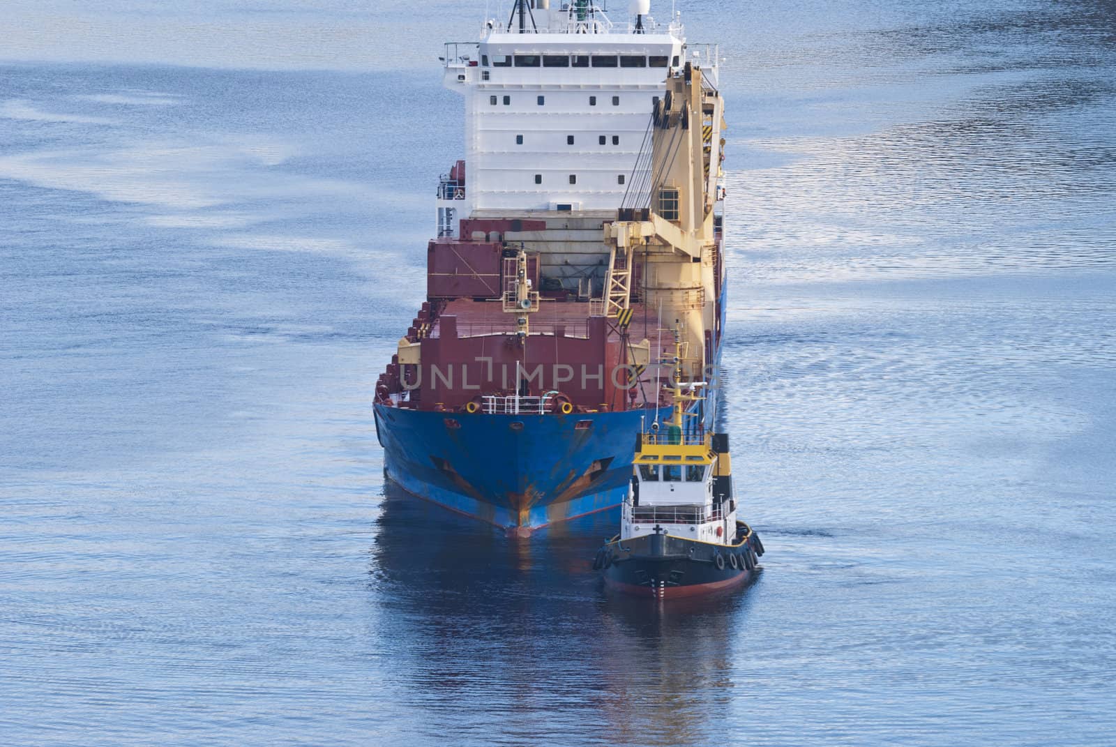 tug herbert moving into ringdalsfjord to assist bbc europe out of the narrowest strait in the fjord, bbc europe is a big cargo ship