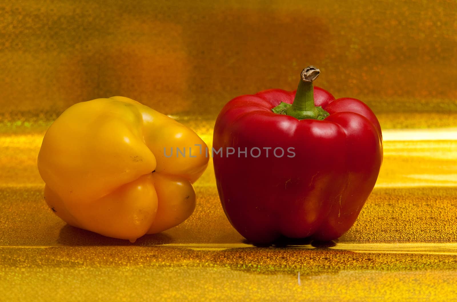 Yellow and red peppers on a golden background.