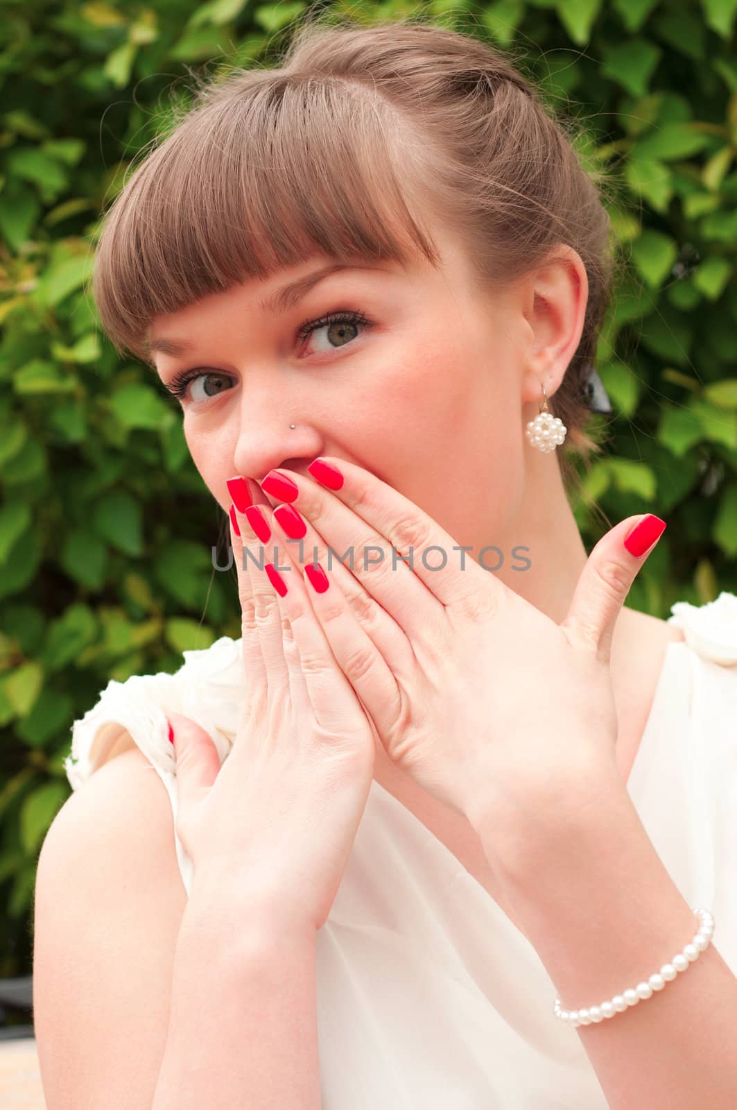 Portrait of a surprised young woman with hands over her mouth