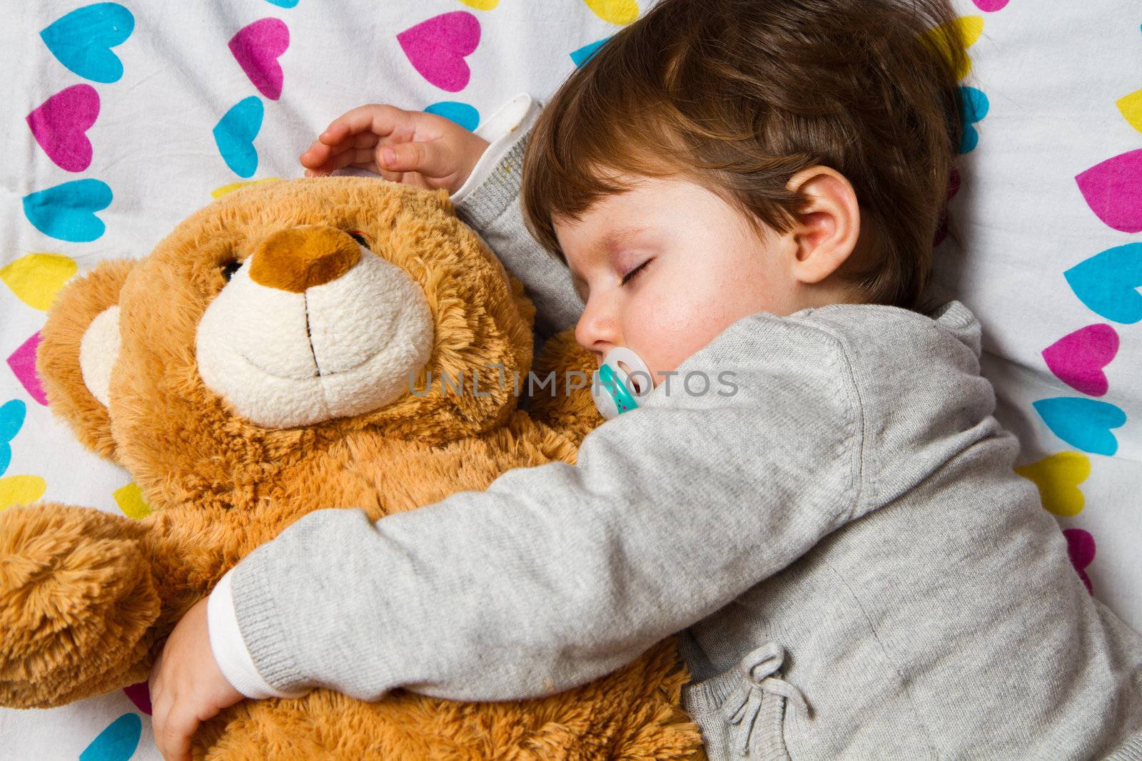 Sweet child sleeping with teddy bear 