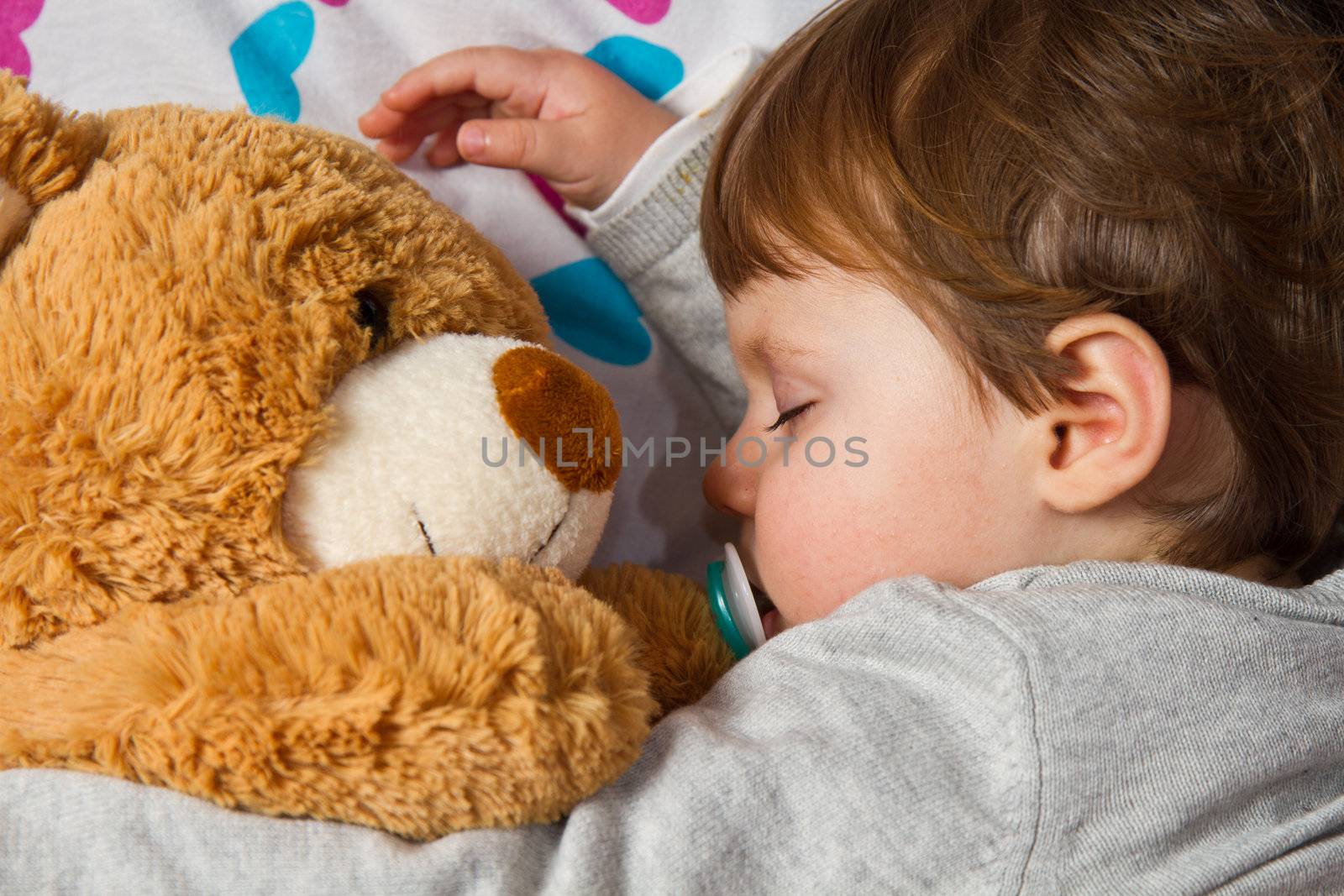 Sweet child sleeping with teddy bear 