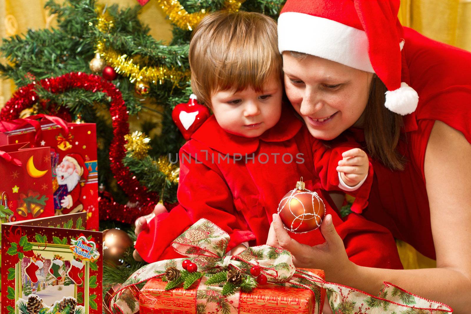 Young motherwith  baby  at Christmas tree 