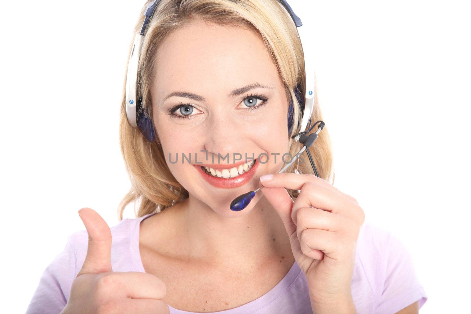 Smiling beautiful young receptionist, call centre operator or secretary wearing a headset and microphone giving a thumbs up gesture isolated on white
