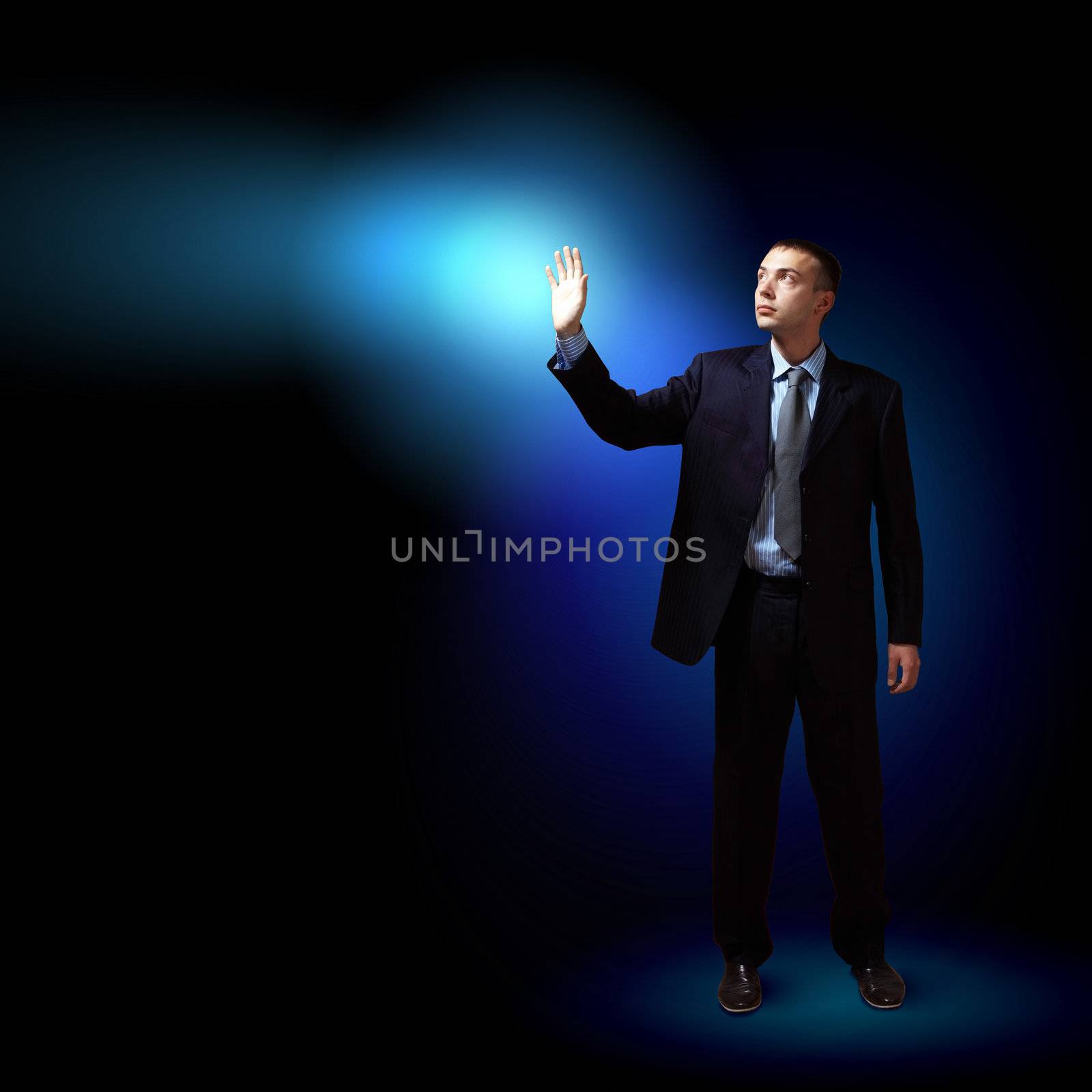 Young successful businessman holding a shining light in his hand as a symbol of success and advancement.