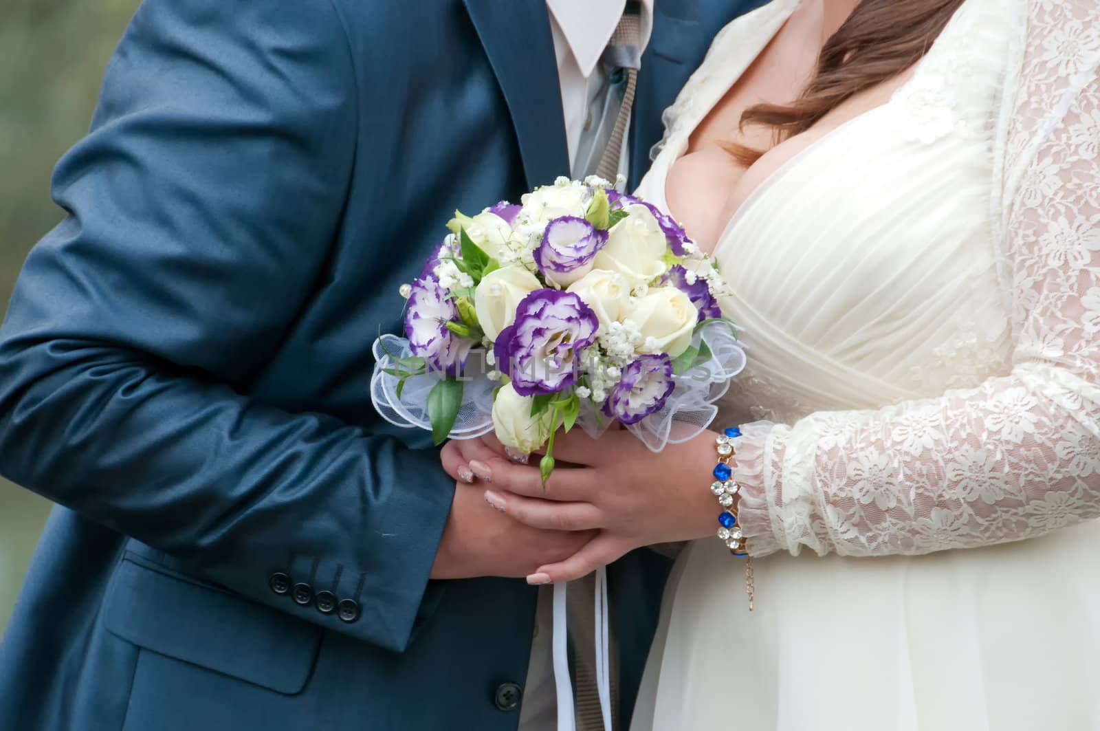 blue and white wedding bouquet in the hands of the bride and groom 