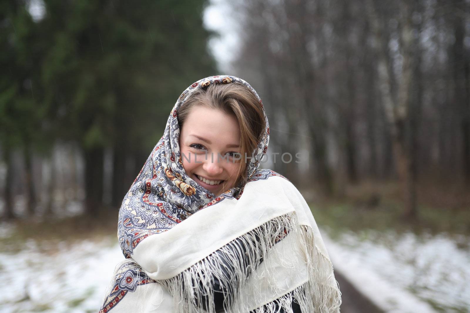 Beautiful young russian girl wearing traditional headscarf on forest background