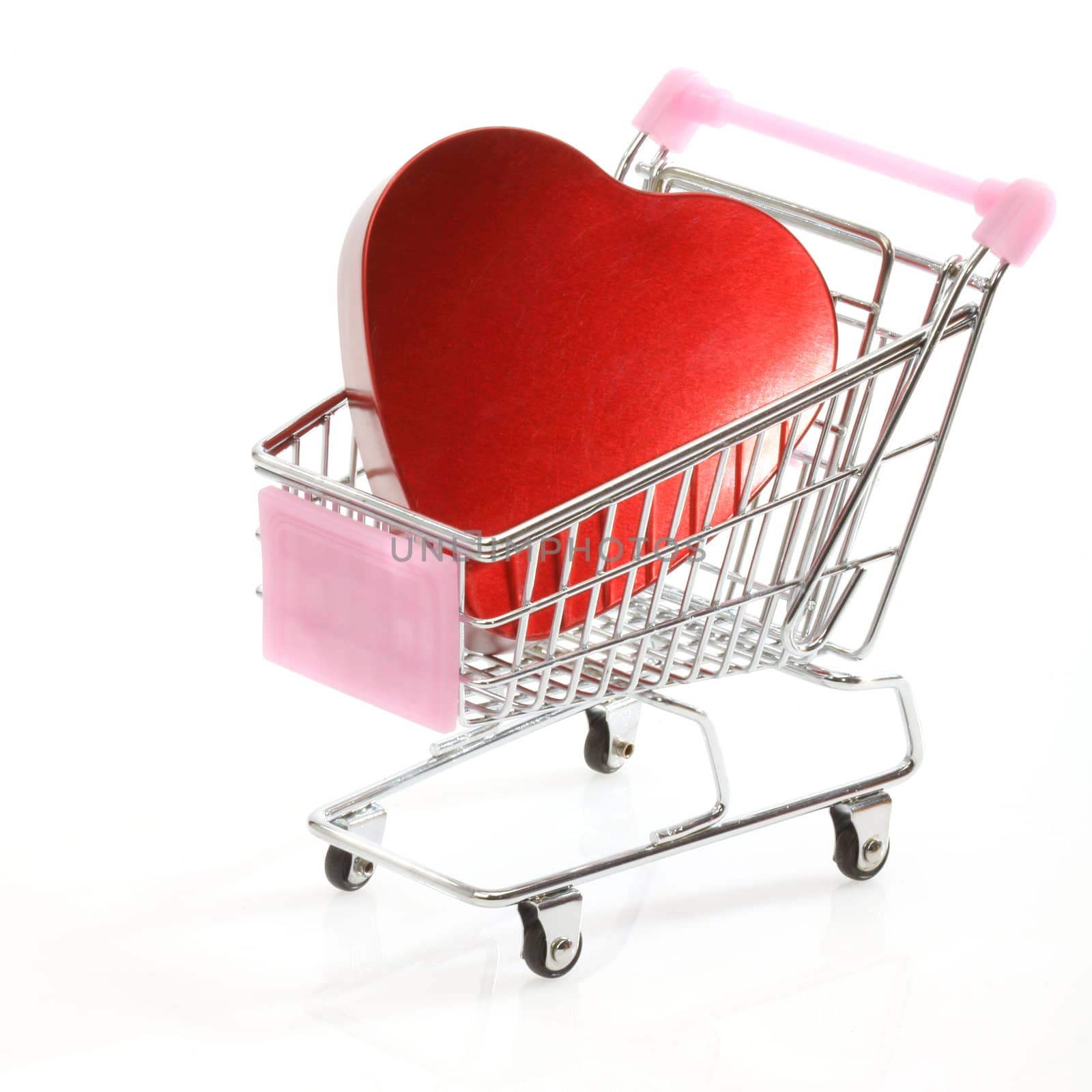 Red heart in shopping cart over white