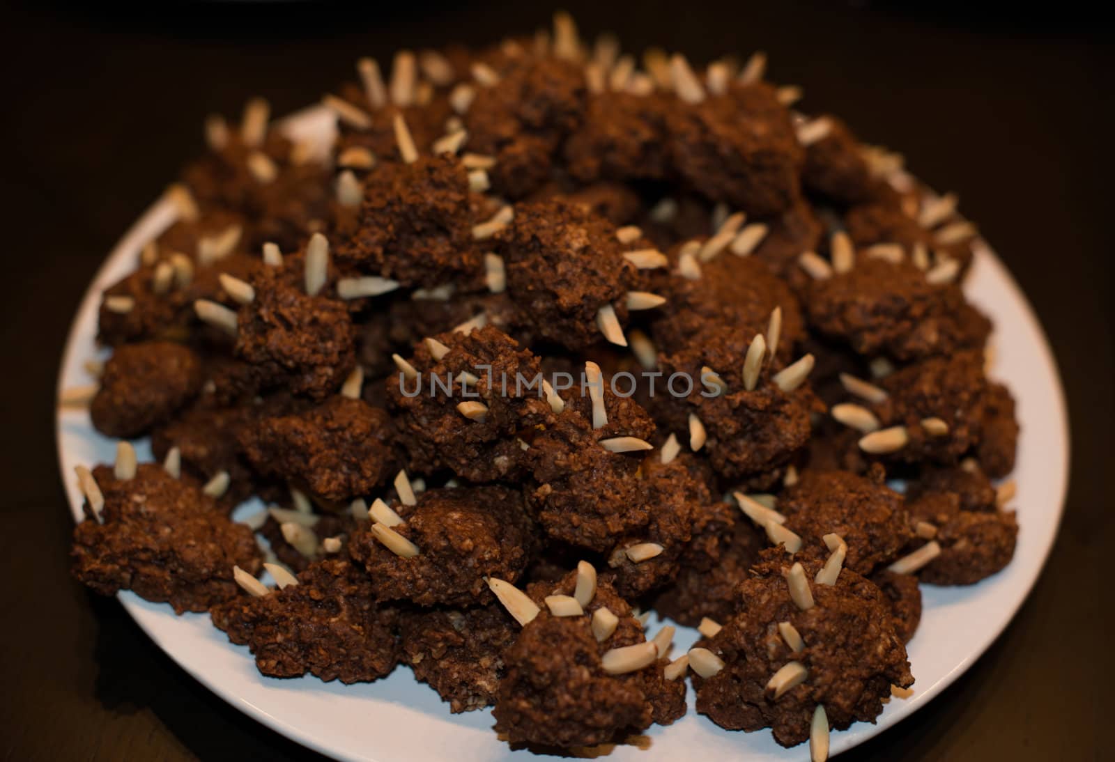 Christmas cakes on a white plate standing on brown wooden background