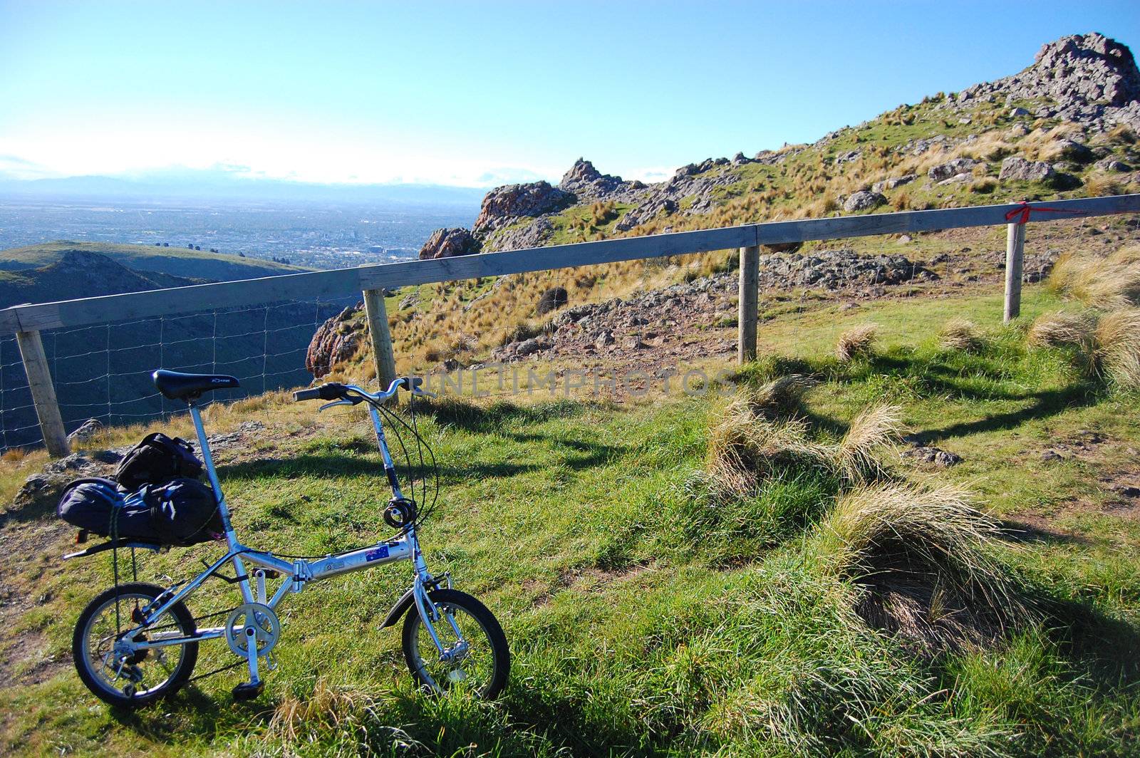 Folding bike on grass near fence by danemo