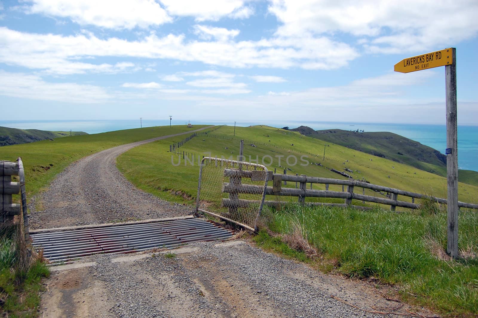 Gravel road with yellow sign in farmland by danemo