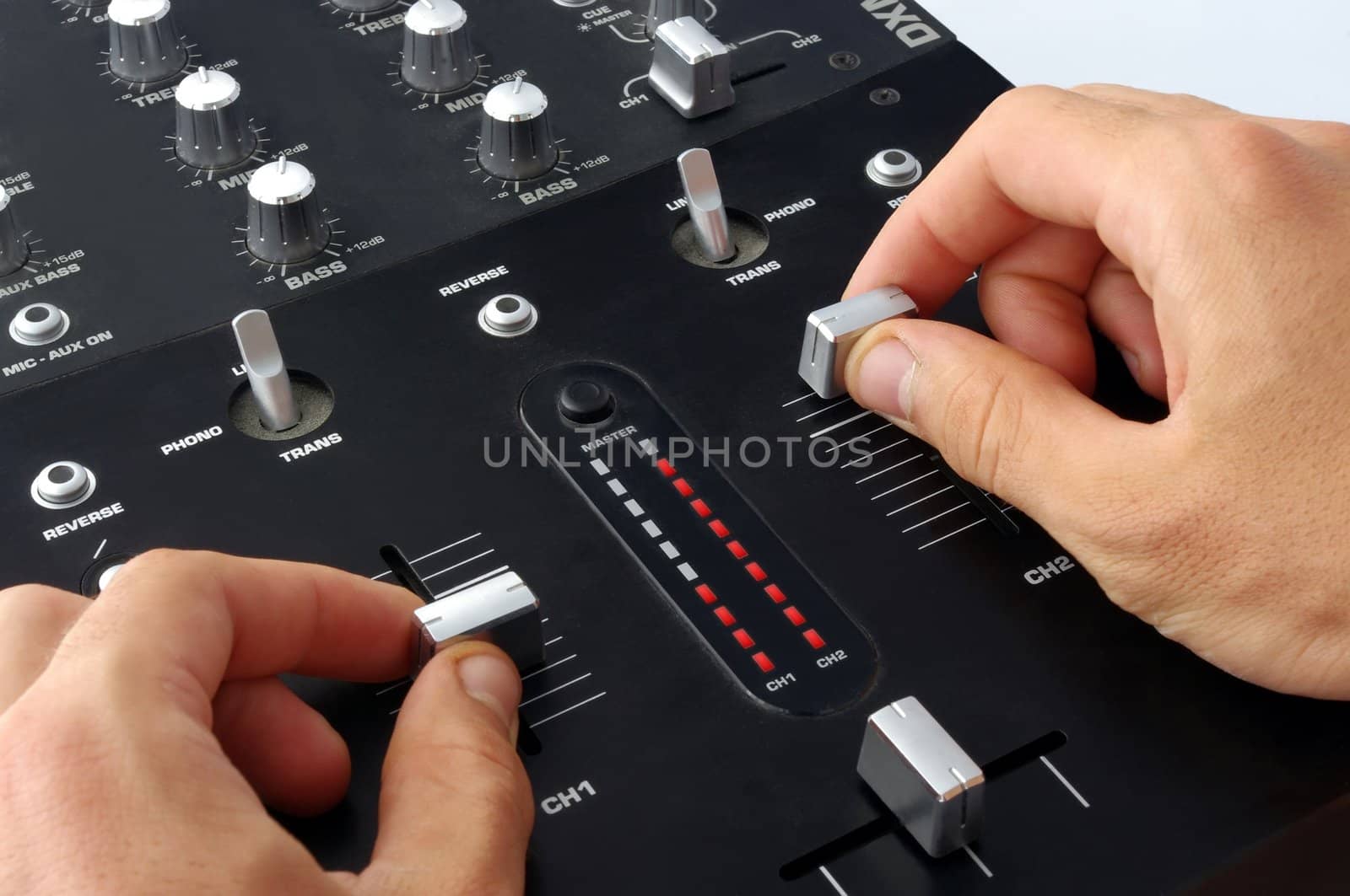 Hand on a audio dj mixer, operating volume