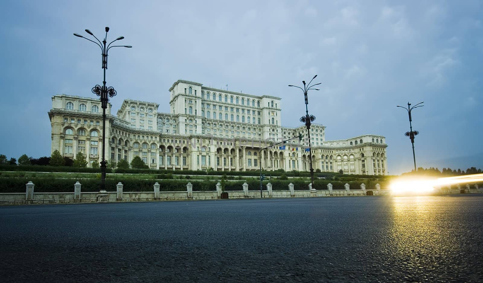 The Palace of the Parliament in Bucharest, Romania and car lights on road