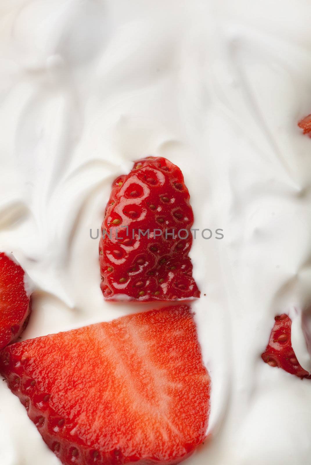 Big strawberry pieces emerging from a desert topping