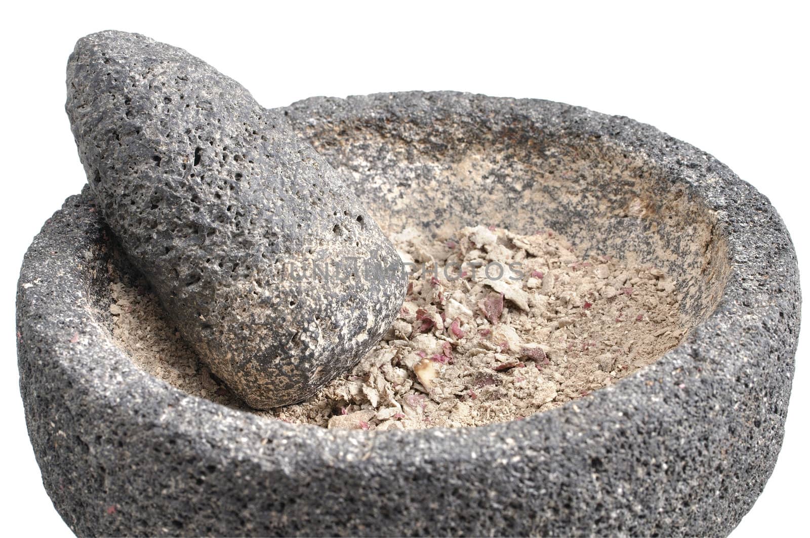 Closeup of ground potato contents of mortar and pestle on white