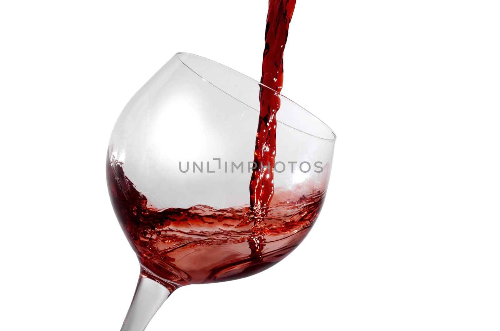 red wine being poured in a tilted wine glass isolation on white