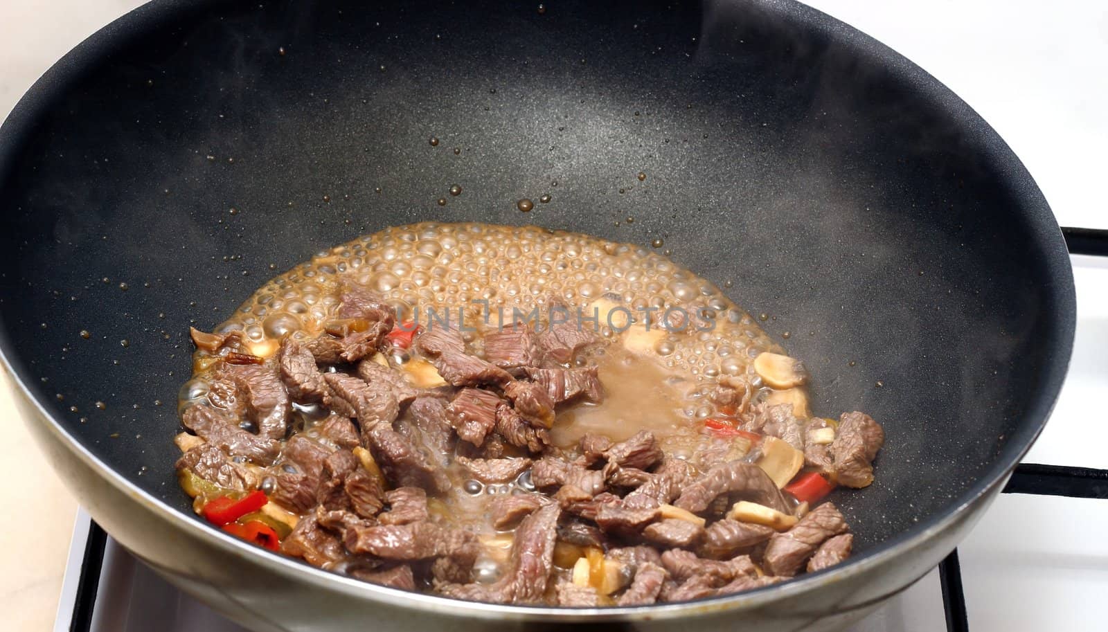 cooking beef with red chilly in a black frying pan