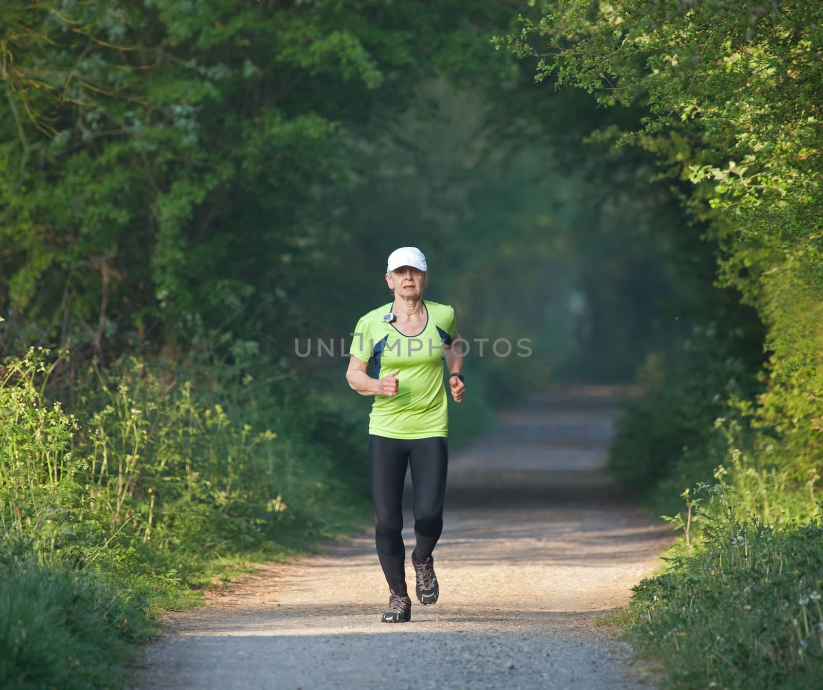 Older woman running on countryside path