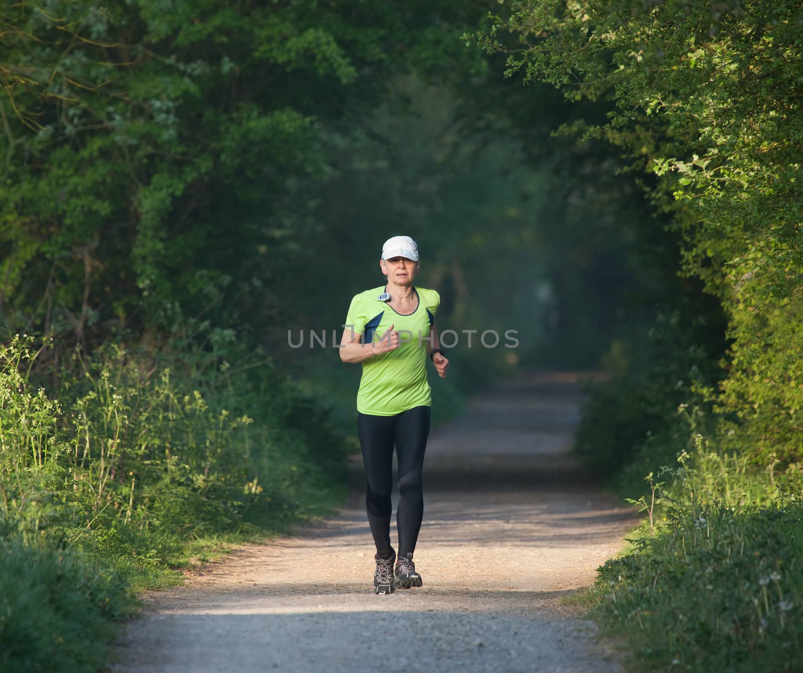 Older woman on training run along countryside path
