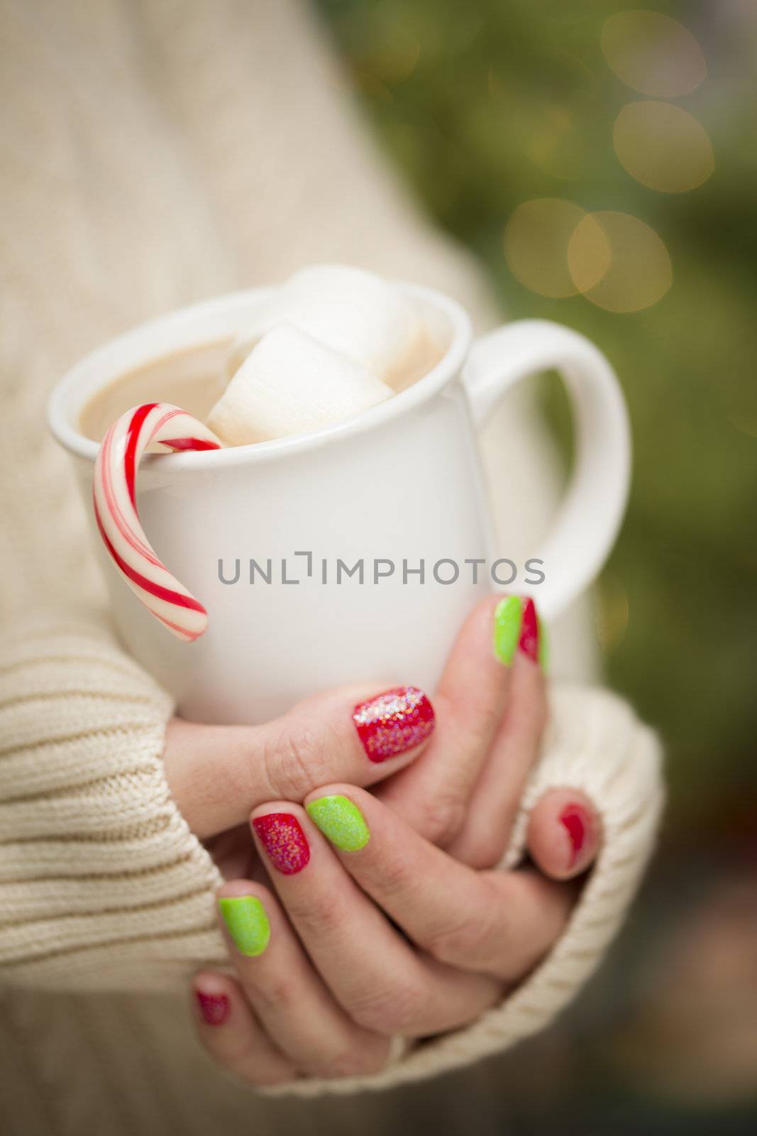 Woman in Sweater with Seasonal Red and Green Nail Polish Holding a Warm Cup of Hot Cocoa.