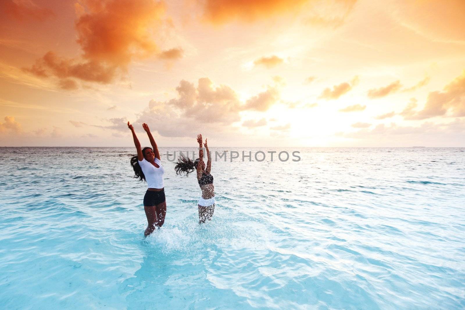 Happy women playing in water by Yellowj