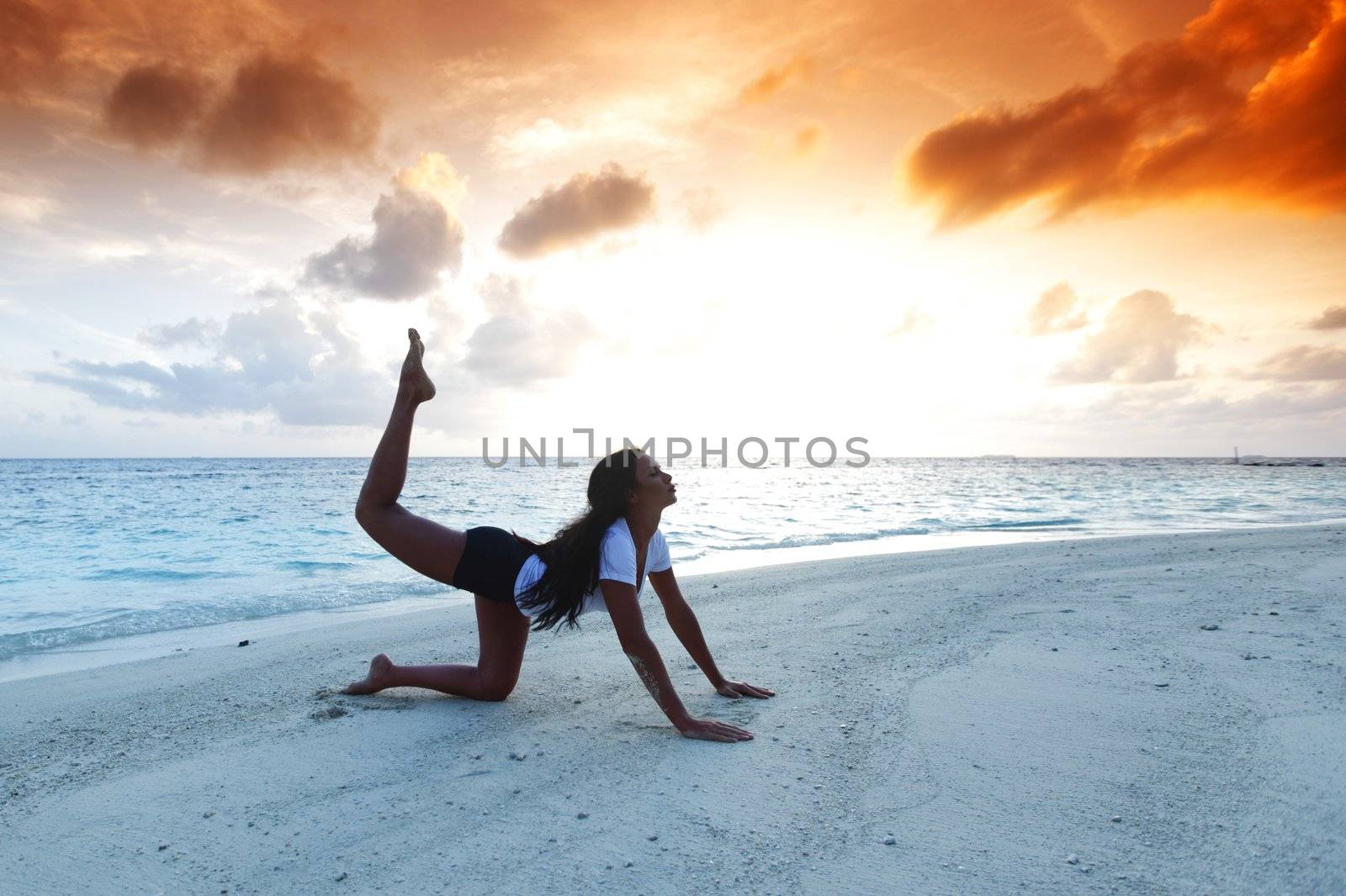 Yoga woman on beach at sunset by Yellowj