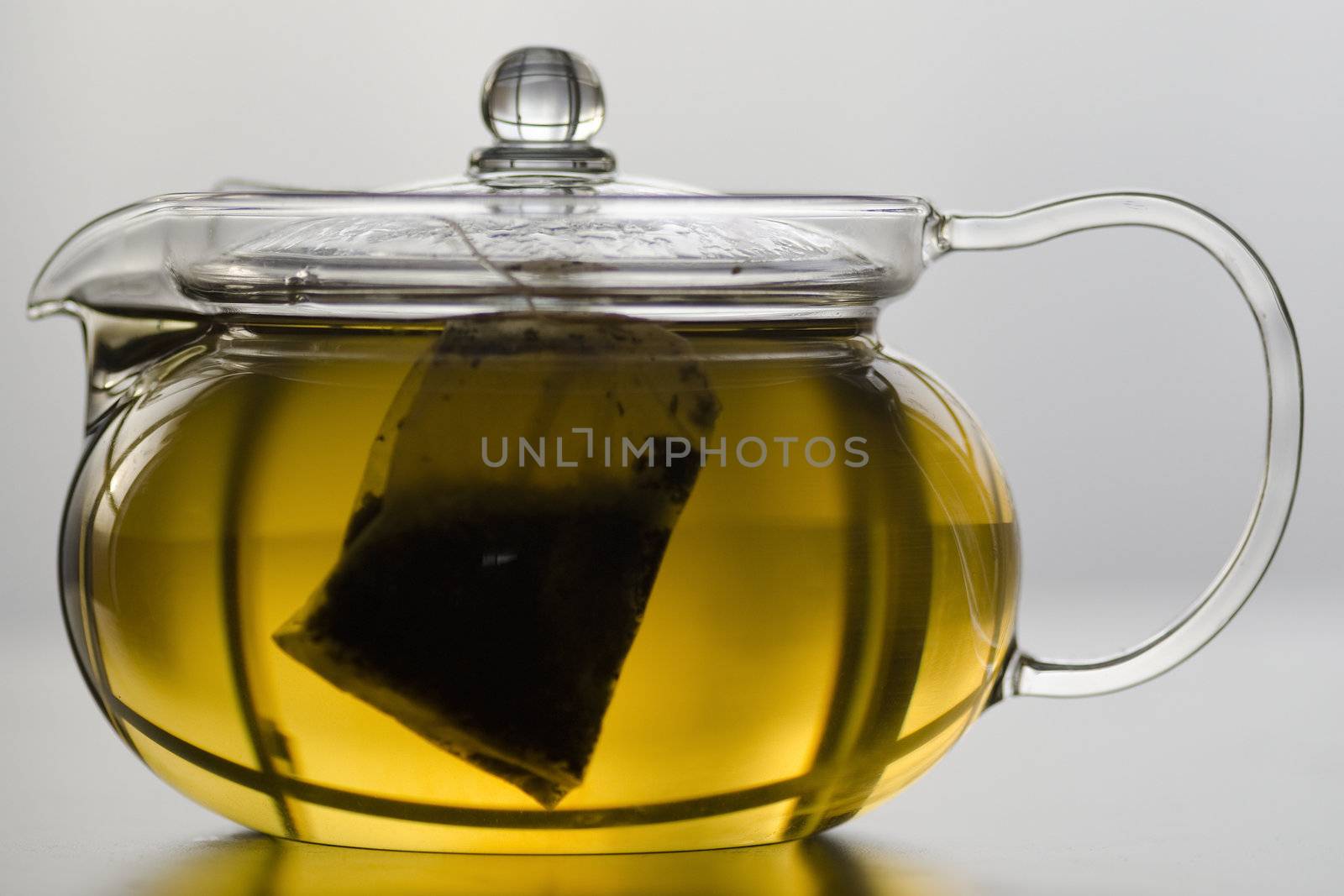 Glass tea pot with herb tea bag and herb tea